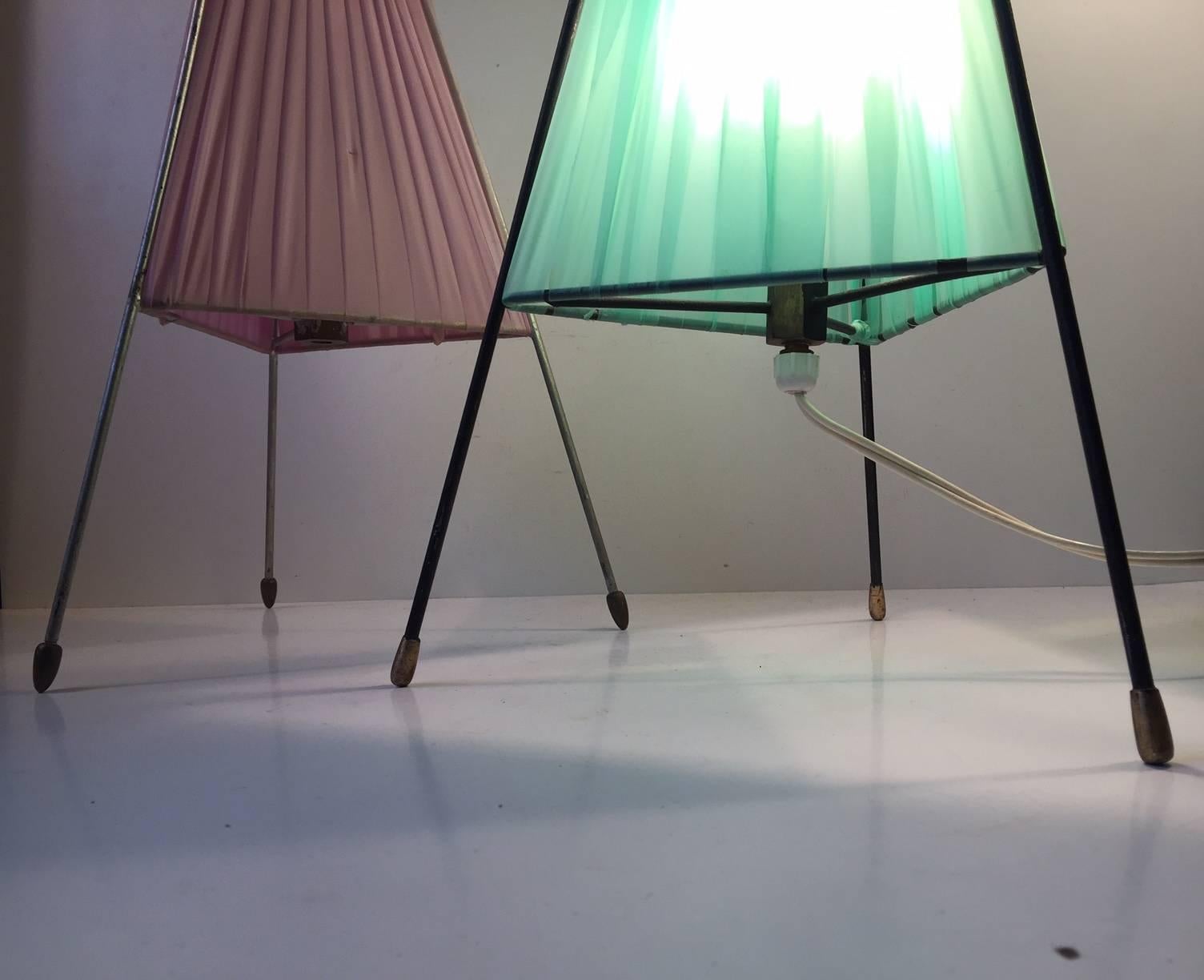 A set of sputnik table lights with steel frames, brass feet and light green and pink acrylic shading. Manufactured and designed anonymously in Italy during the 1950s in a style reminiscent of Stilnovo. Both of them will be shipped in working
