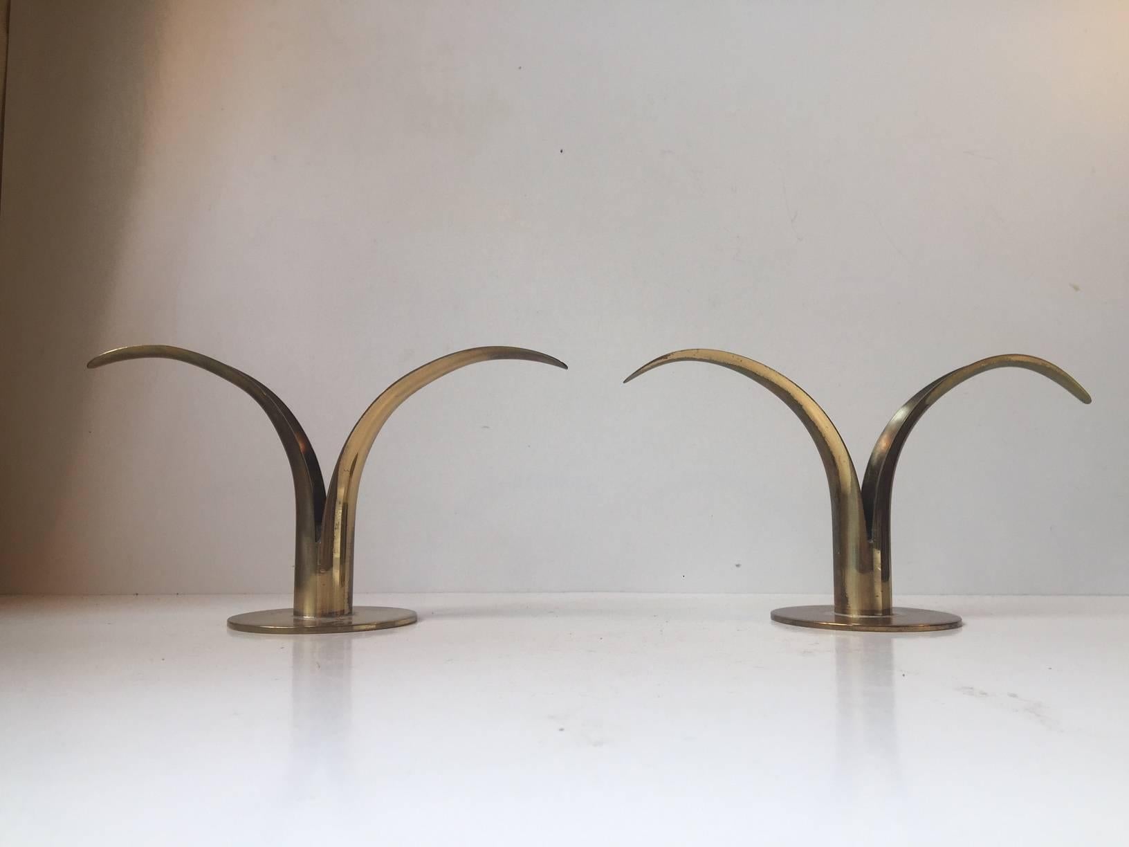 A Pair of brass candle holders designed by Ivar A°lenius Bjo¨rk. The model is called the 