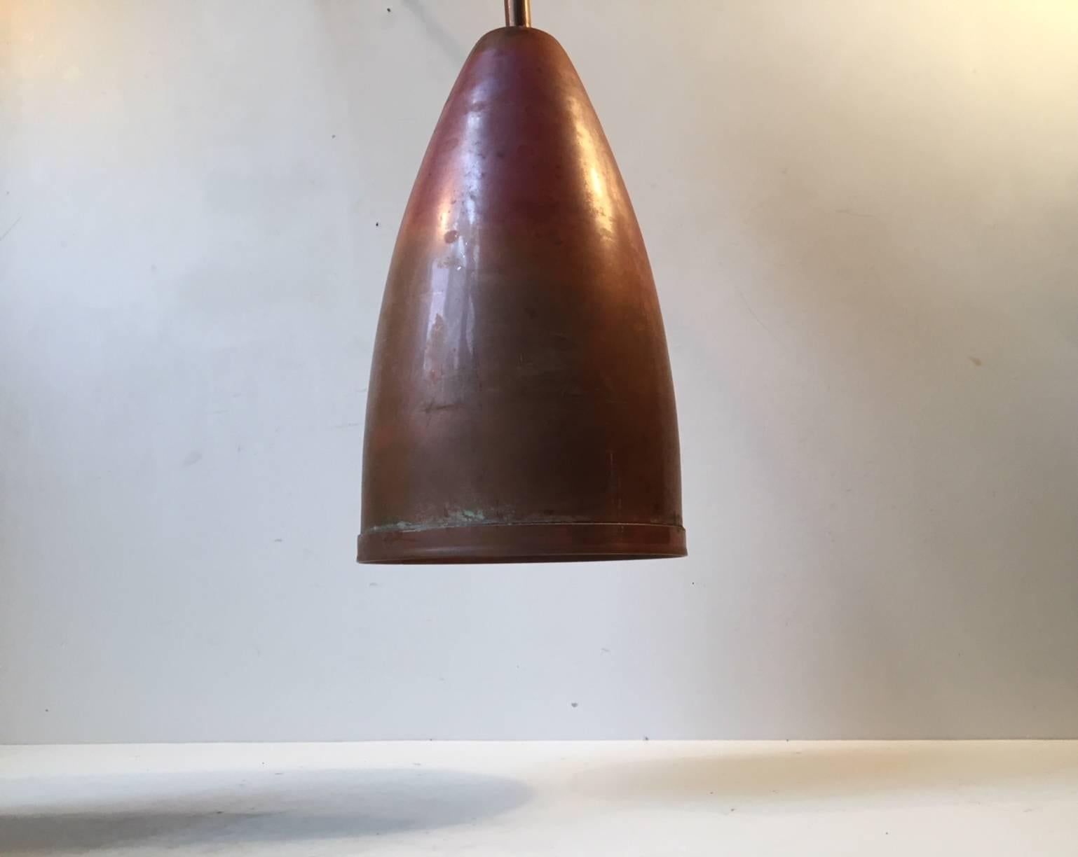 A Pair of Bullet shaped solid copper pendant lamps with matching red patina. Manufactured by Kobberkompagniet in Denmark during the 1960s.