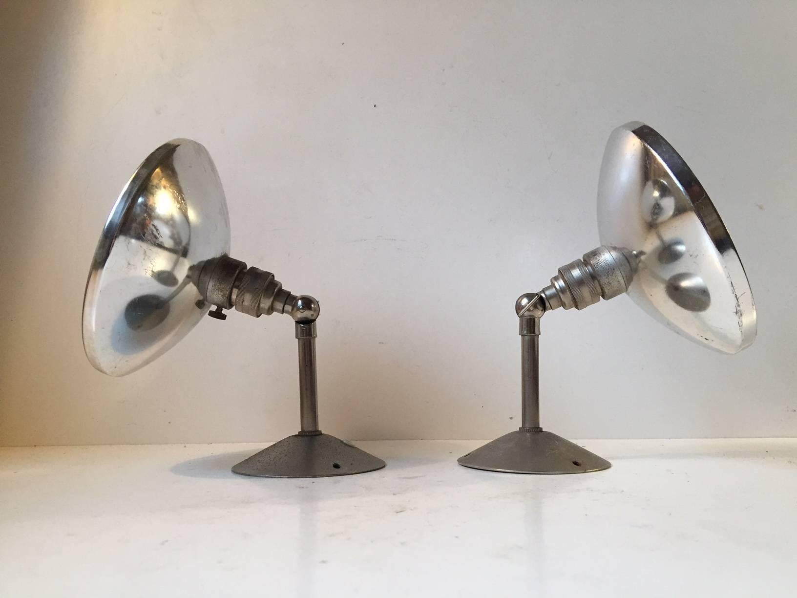 A set of two French wall lights with engine turned stems and aluminium shades. They have come out of an old warehouse. The style is reminiscent of Jielde and Bauhaus fixtures. They are fitted with their original Bajonet socket.