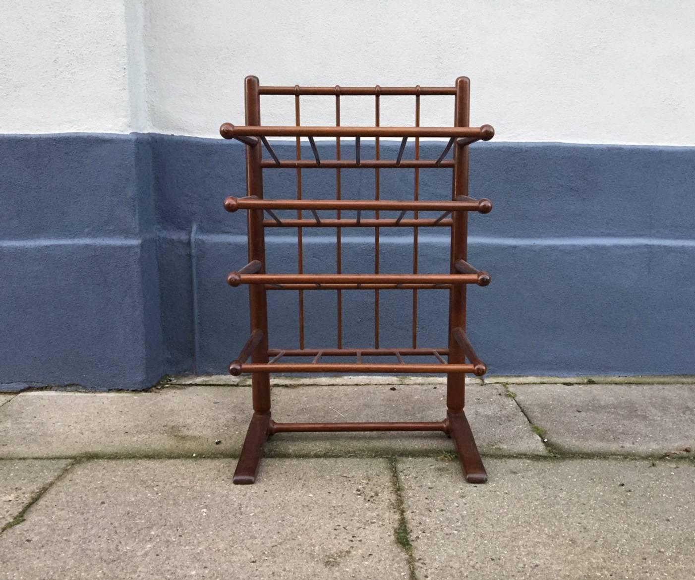Magazine or shoe rack designed by Frits Henningsen and manufactured by Andreas Tuck in Denmnark during the 1940s. The solid mahogany frame features Drumstick detaling and bend/shaped wood detailing.
