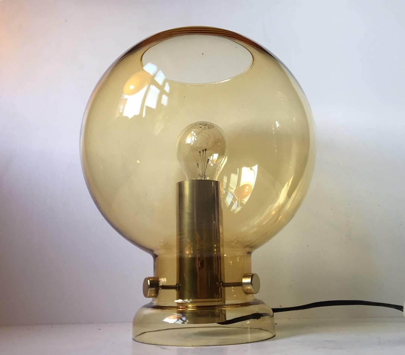 A very rare table lamp designed by Hans-Agne Jakobsson and manufactured by Markaryd AB in Sweden during the 1960s. Composed of yellow toned smoke-glass and gilded brass. Please notice that is has smoke chips to the foot/base.