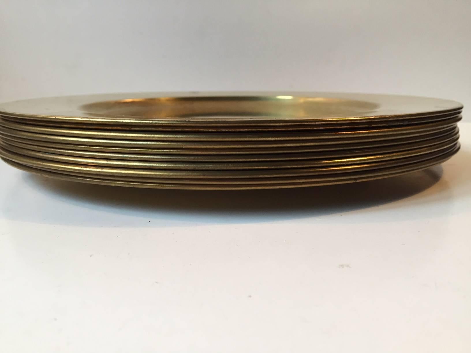 Set of ten cover plates or dishes in solid brass. Manufactured by Stelton in Denmark during the 1970s. The plates are unpolished and shows light ware and patina here and there. You can polish them up to a full shine if you wish. On request the set