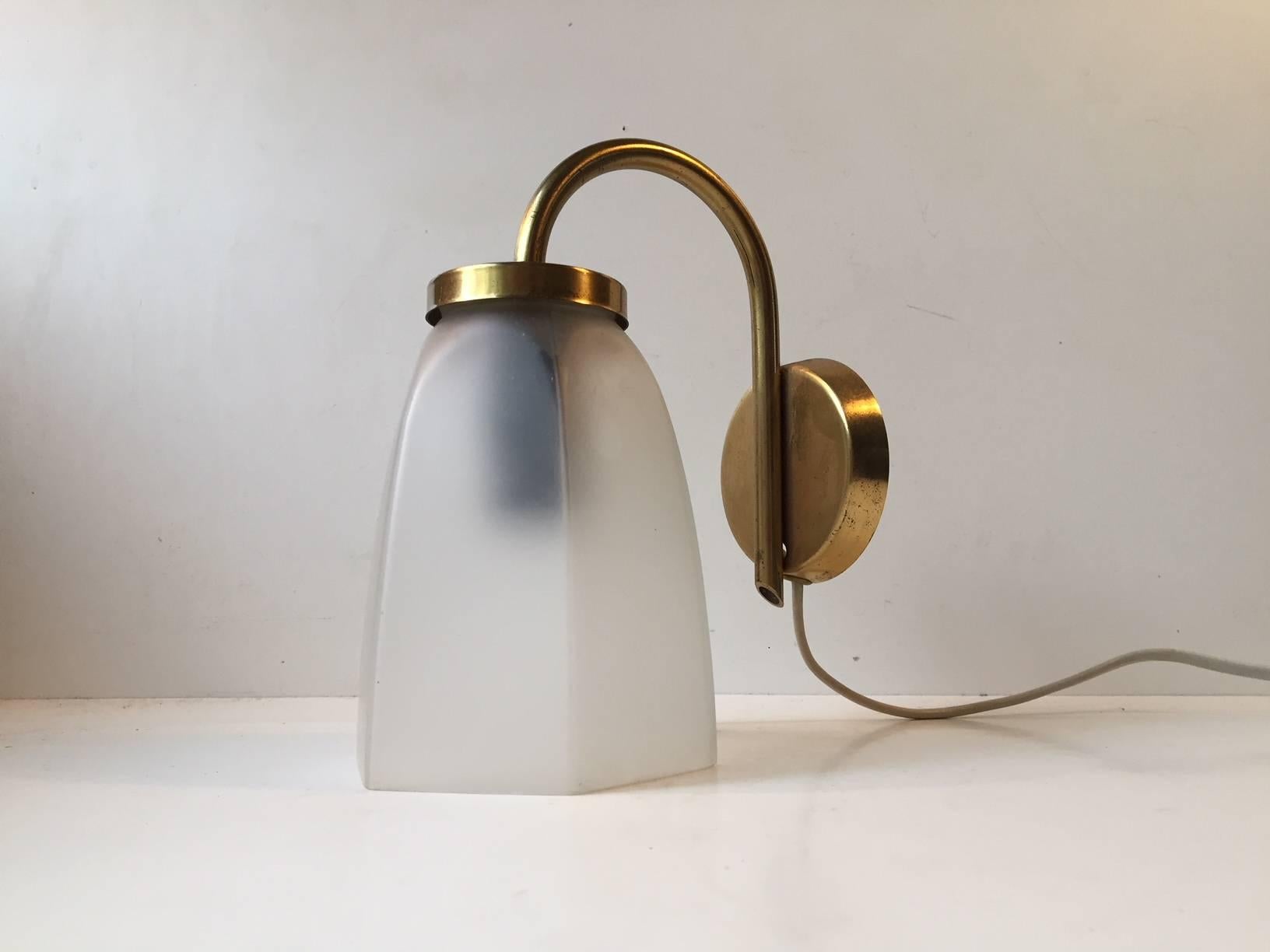 This lounge sconce was designed and manufactured by Lyfa in Denmark during the 1950s. Its composed of single-layered frosted glass and brushed brass.