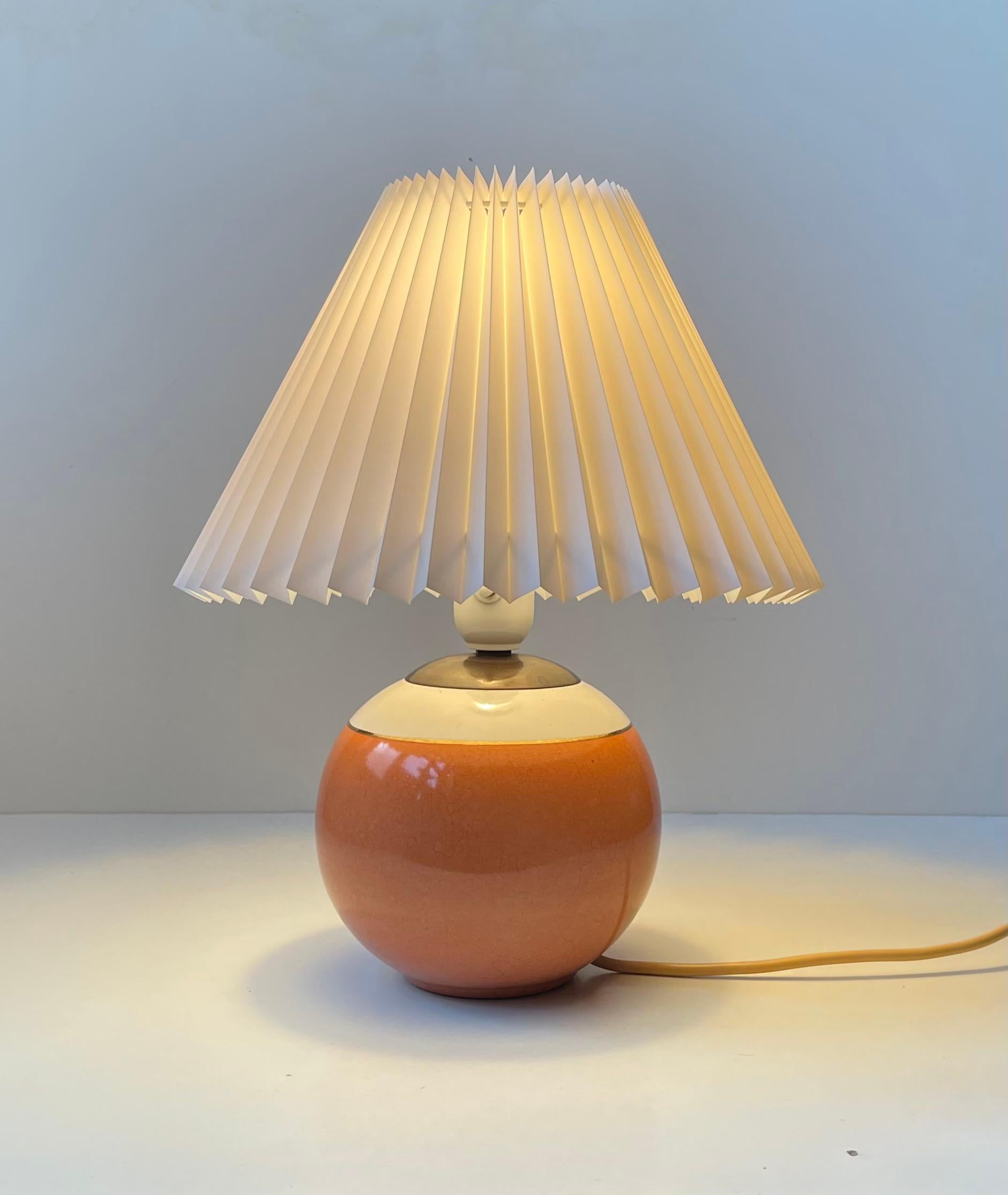 A stylish table light in glazed ceramic and bronze. 3 colors high-lighted by a small stripe in gold-glaze. It features its original white bakelite socket with a practical on/off push switch. It comes with a new fluted white shade.  

Measurements: