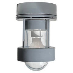 Lámpara minimalista gris de Louis Poulsen para pared o techo, ideal para exteriores o el baño
