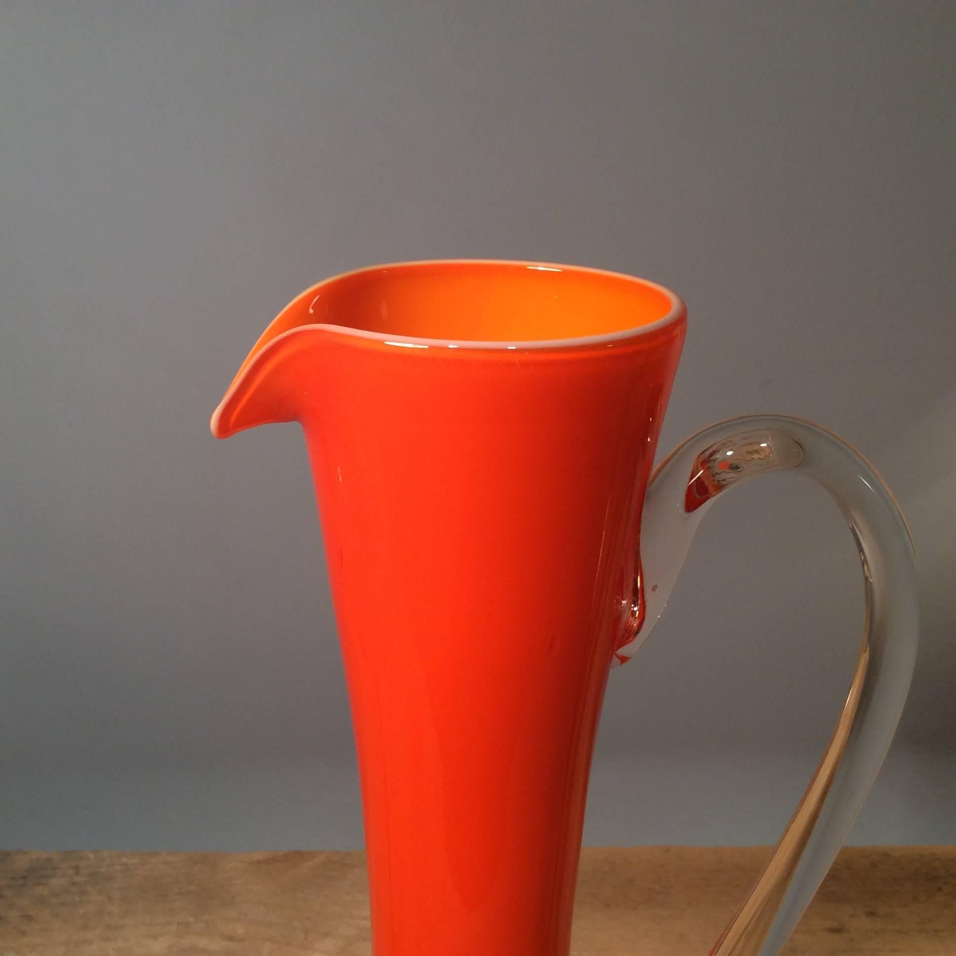 This brilliant orange retro glass jug will make any room pop with it's groovy shape and contrasting clear glass handle, 1970s.

Dimensions: Height 31 cm, diameter 17 cm.