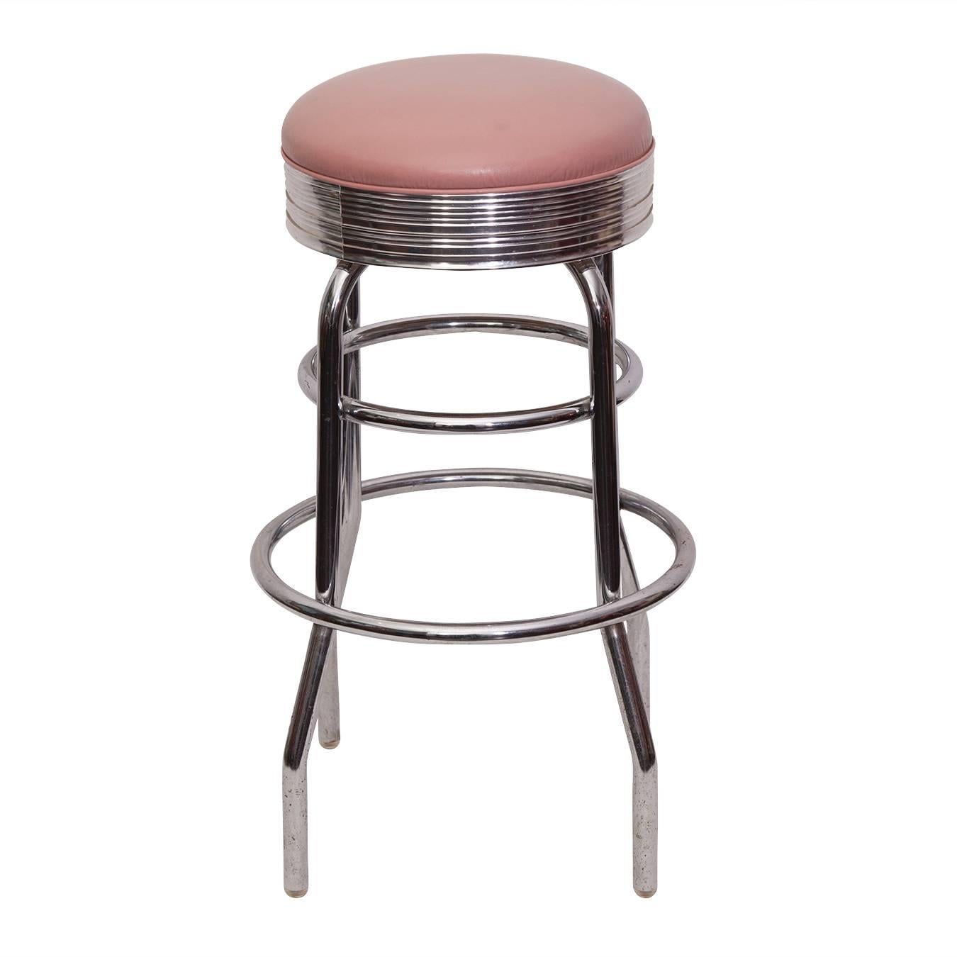 Retro 1960s chrome bar with pink leather stools.