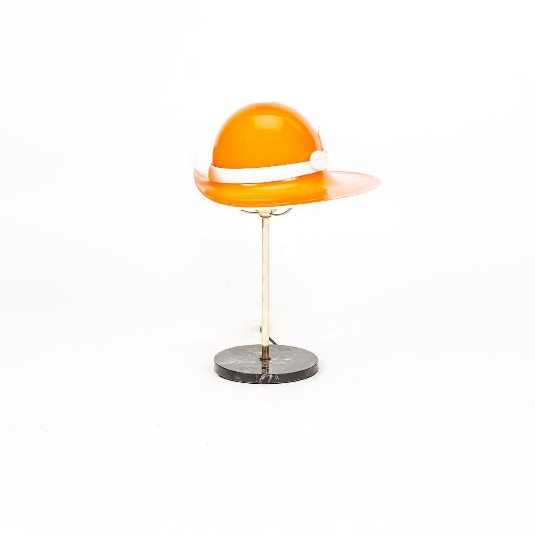 A charming table lamp whimsically made in the shape of a hat in orange Murano glass.

Base: 7'' L x 7'' W
