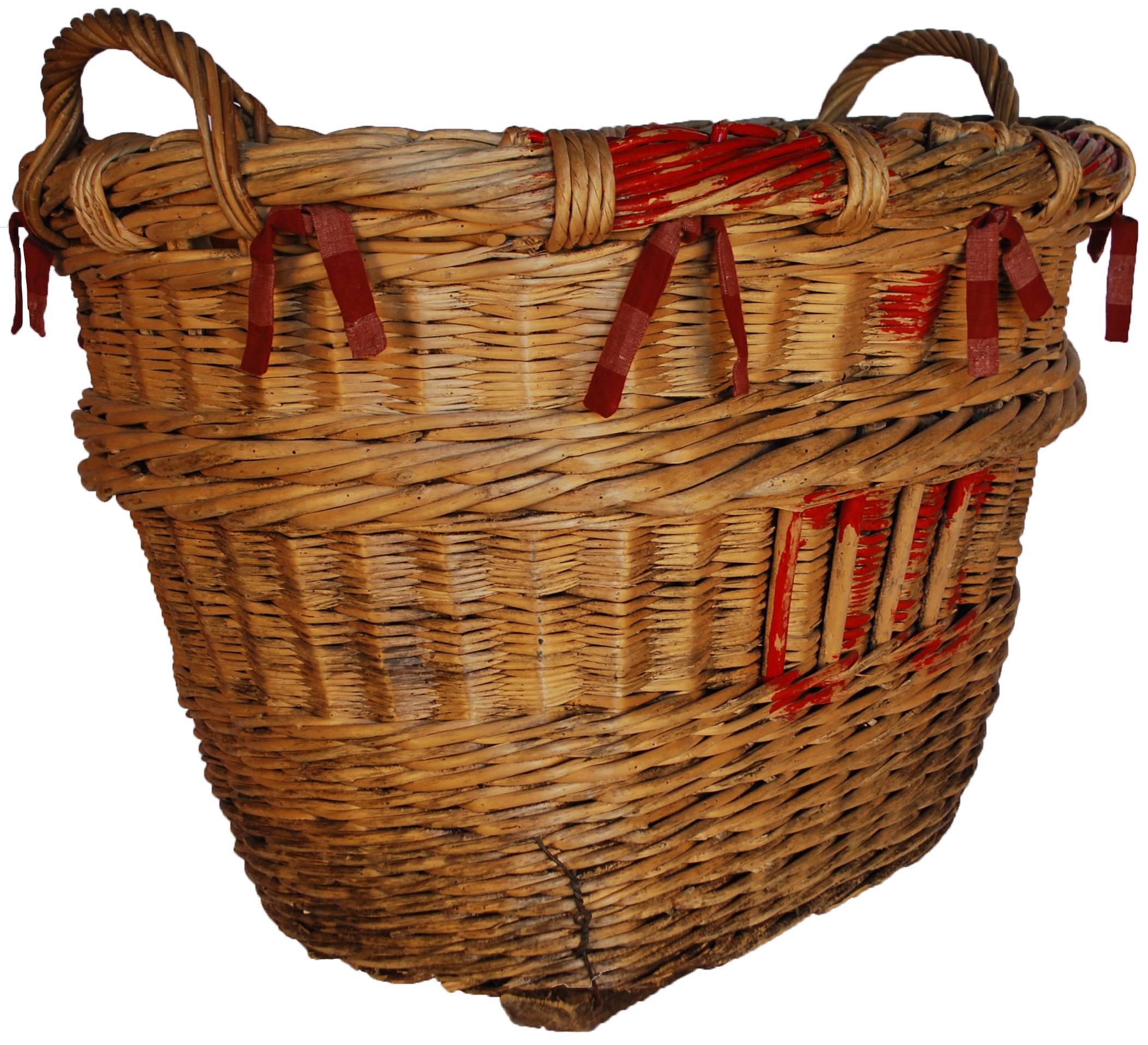 Large French wicker storage basket lined in red and white check fabric.