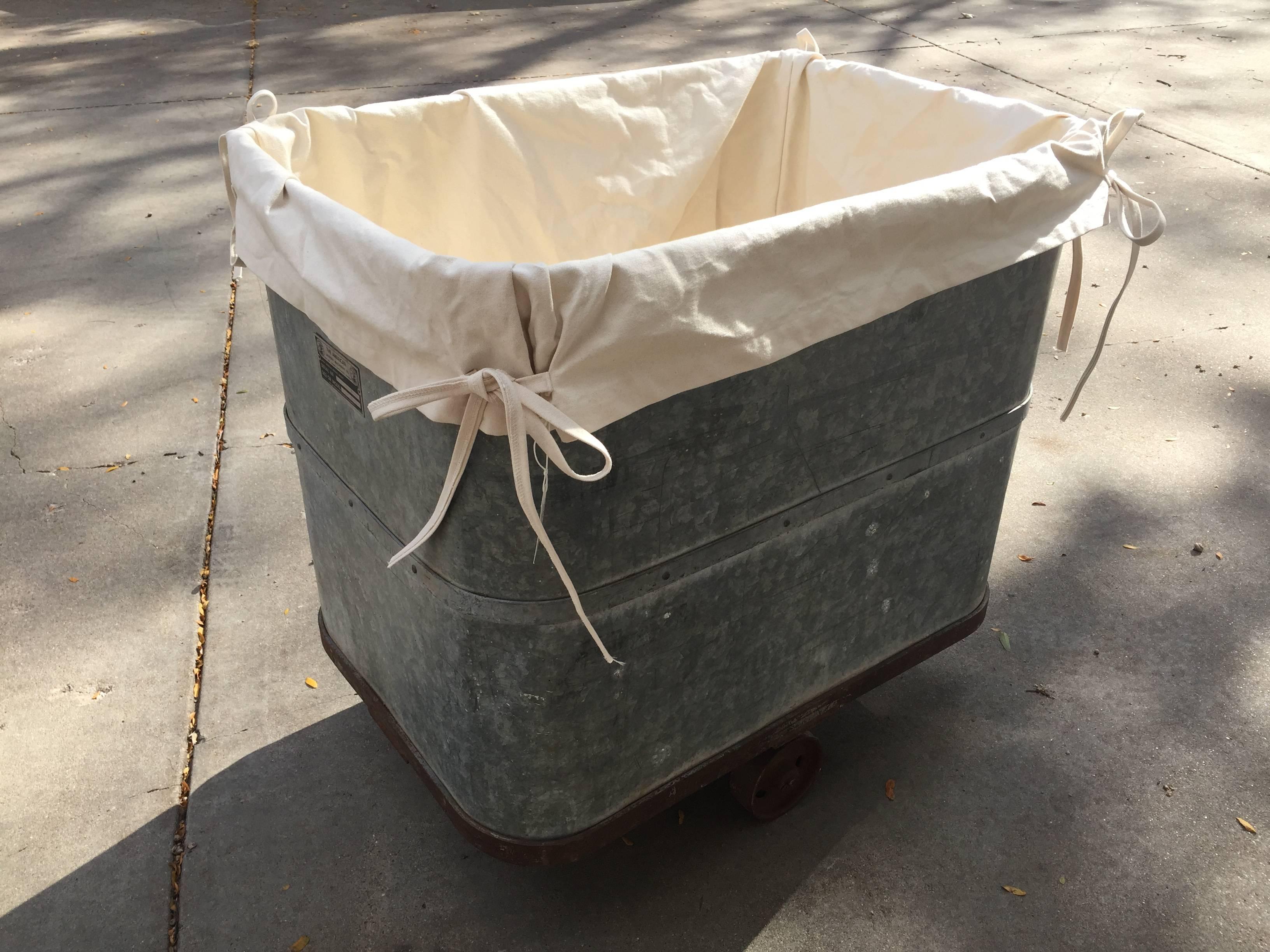 Vintage industrial laundry cart with new liner and working original wheels.