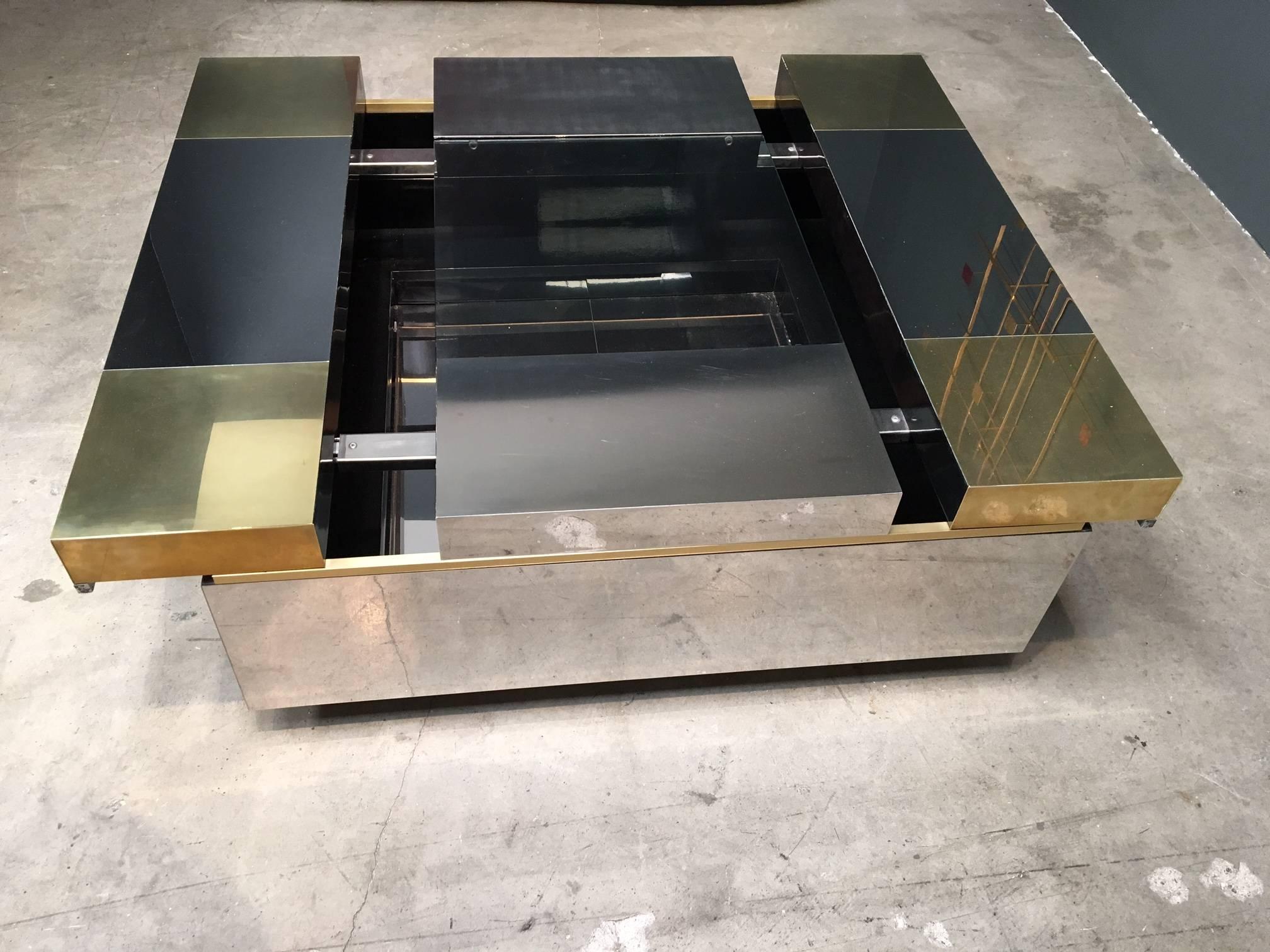 

Italian coffee table
Attributed to Pierre Cardin.
Top slides open for bar or display,

1960-1969.
Brass, stainless steel and glass