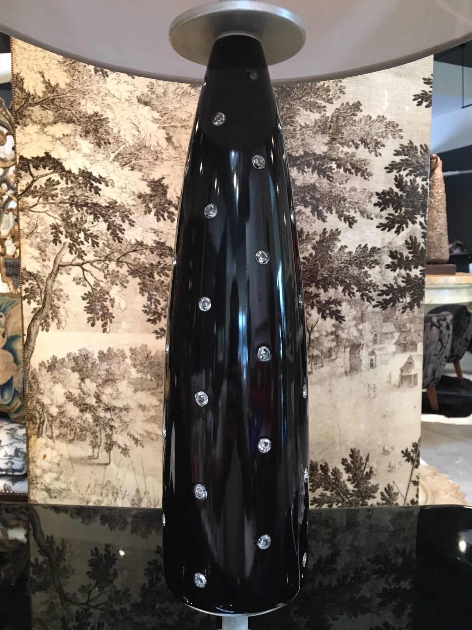 A black lacquer and jeweled table lamp in the style of Tommi Parzinger.