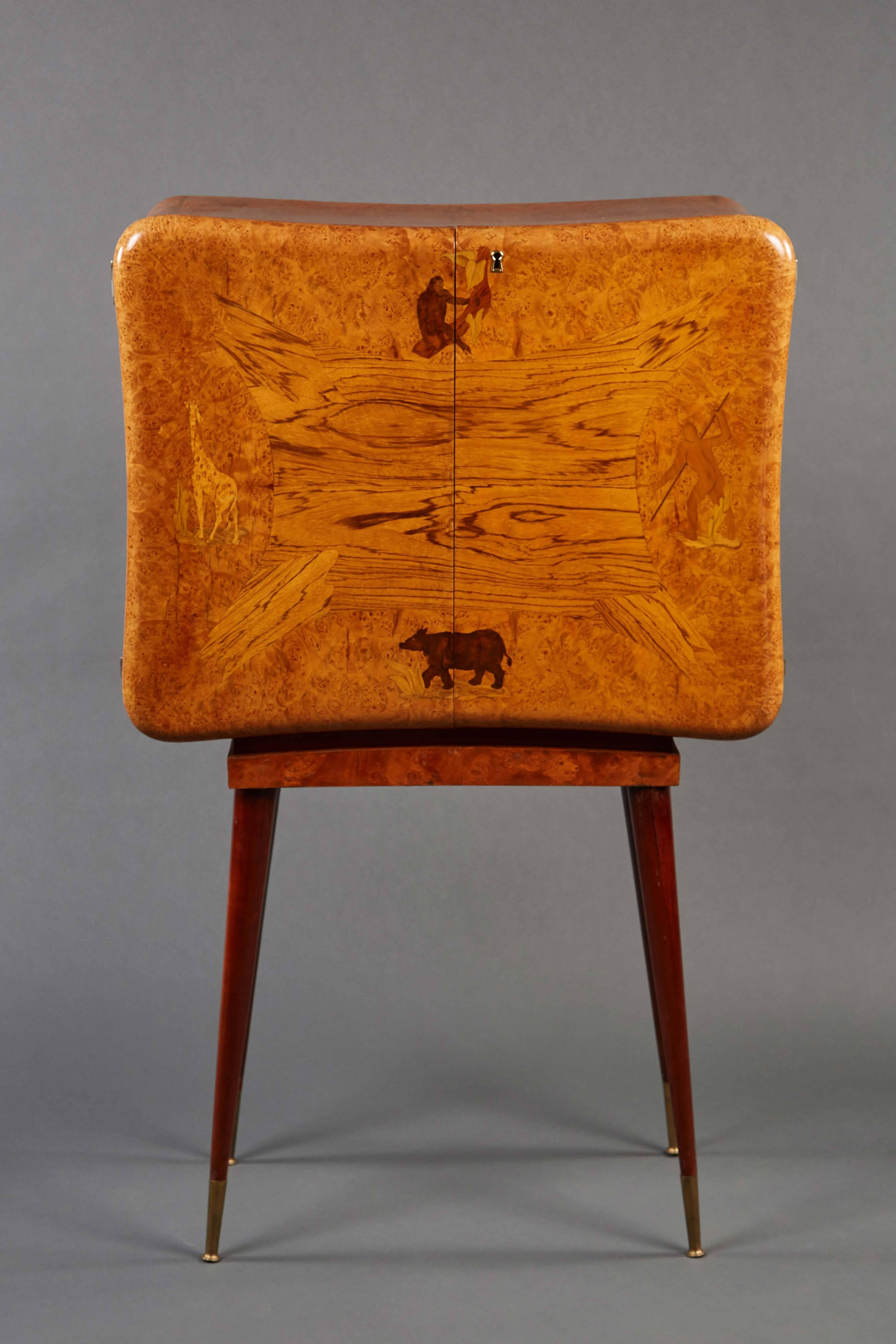 A bold and stunning high marquetry dry bar depicting animals and hunter, with its body resting on four tapered legs terminating in brass sabots.