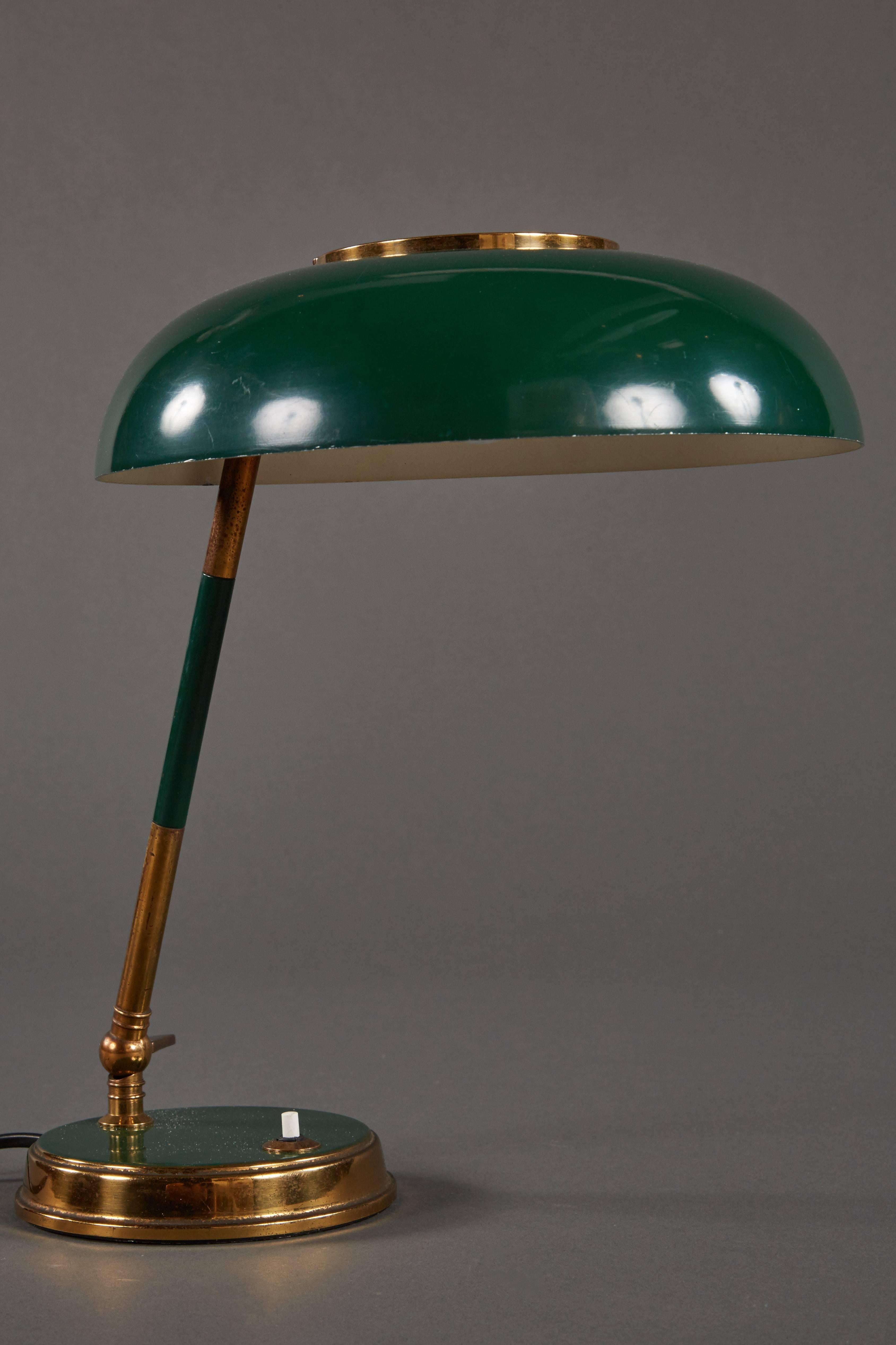 A graceful and stunning Oscar Torlasco table lamp For Lumi, featuring an adjustable green and white painted shade with perforated metal and brass.