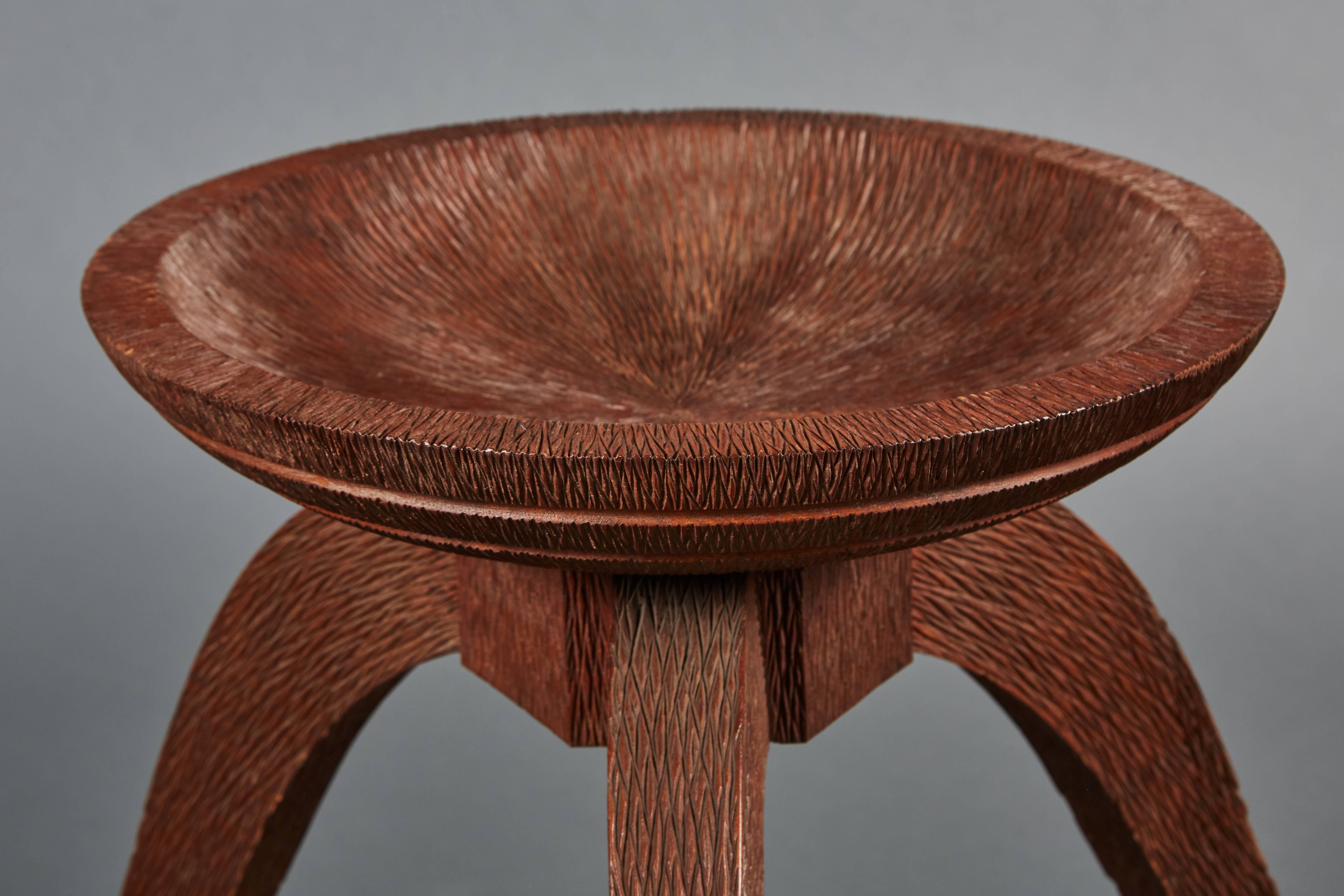 An extremely rare and spectacular Osvaldo Borsani chiselled and hand-carved wood low table. Walnut table base has a detailed chiselled bowl top, resting on three legs and exhibiting Primitive themes, supporting a beautiful thick glass top.