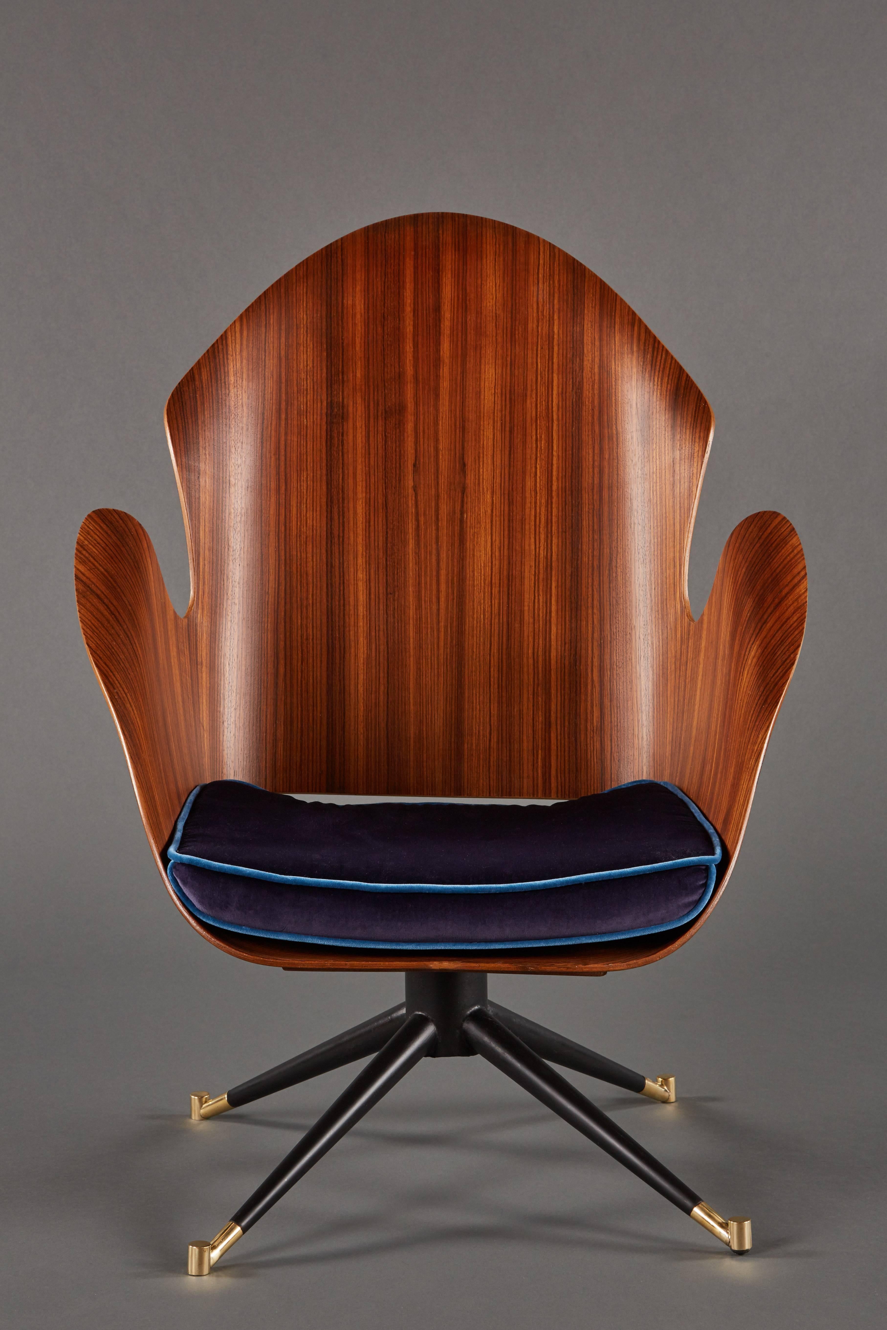 A rare and sculptural pair of Mid-Century Italian swivel chairs made of shaped fruitwood, above steel and brass legs.