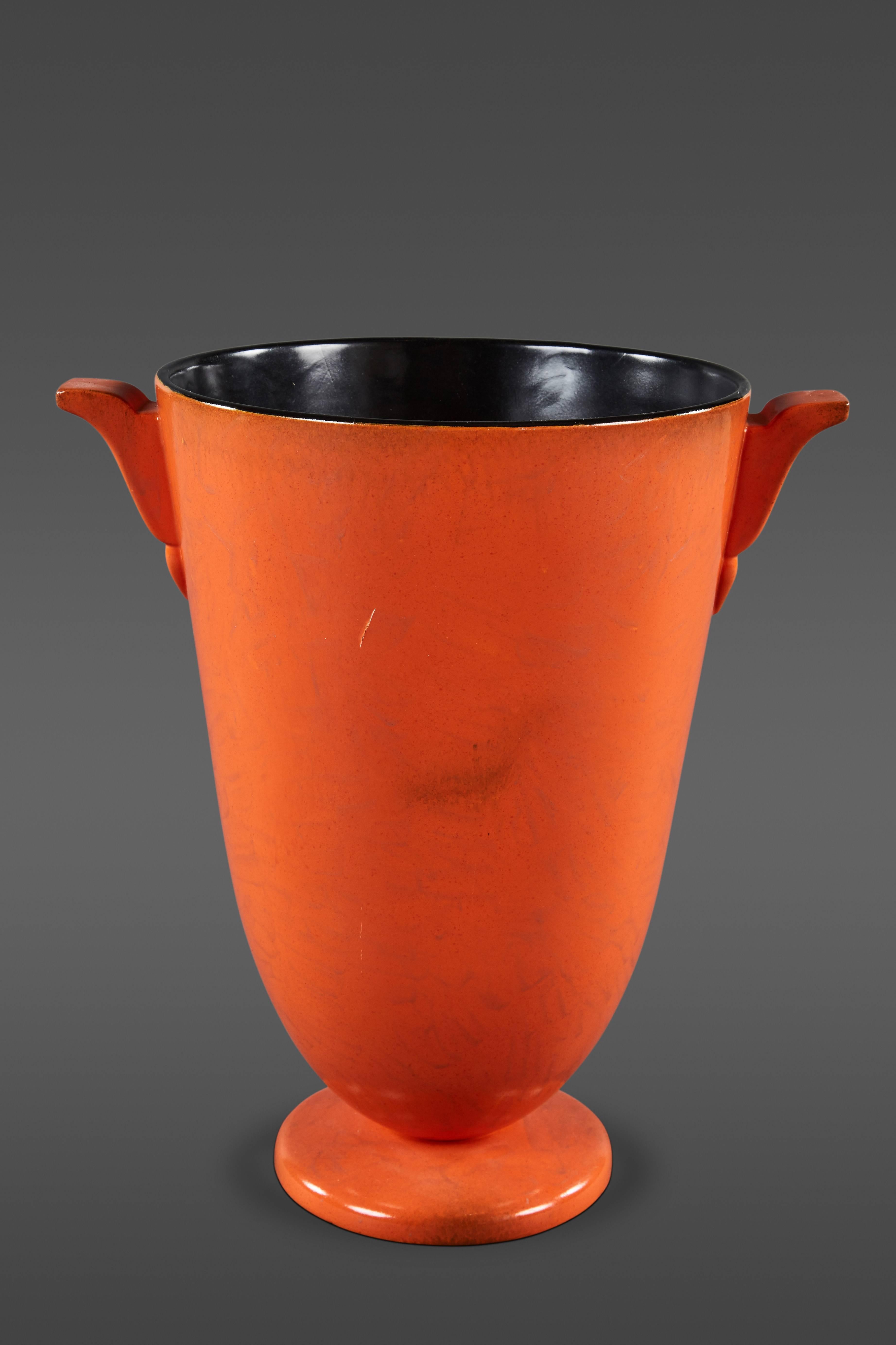 A striking and large mottled Italian orange glaze ceramic vase, exhibiting ear handles and resting on a disc base. Stamped on underside.