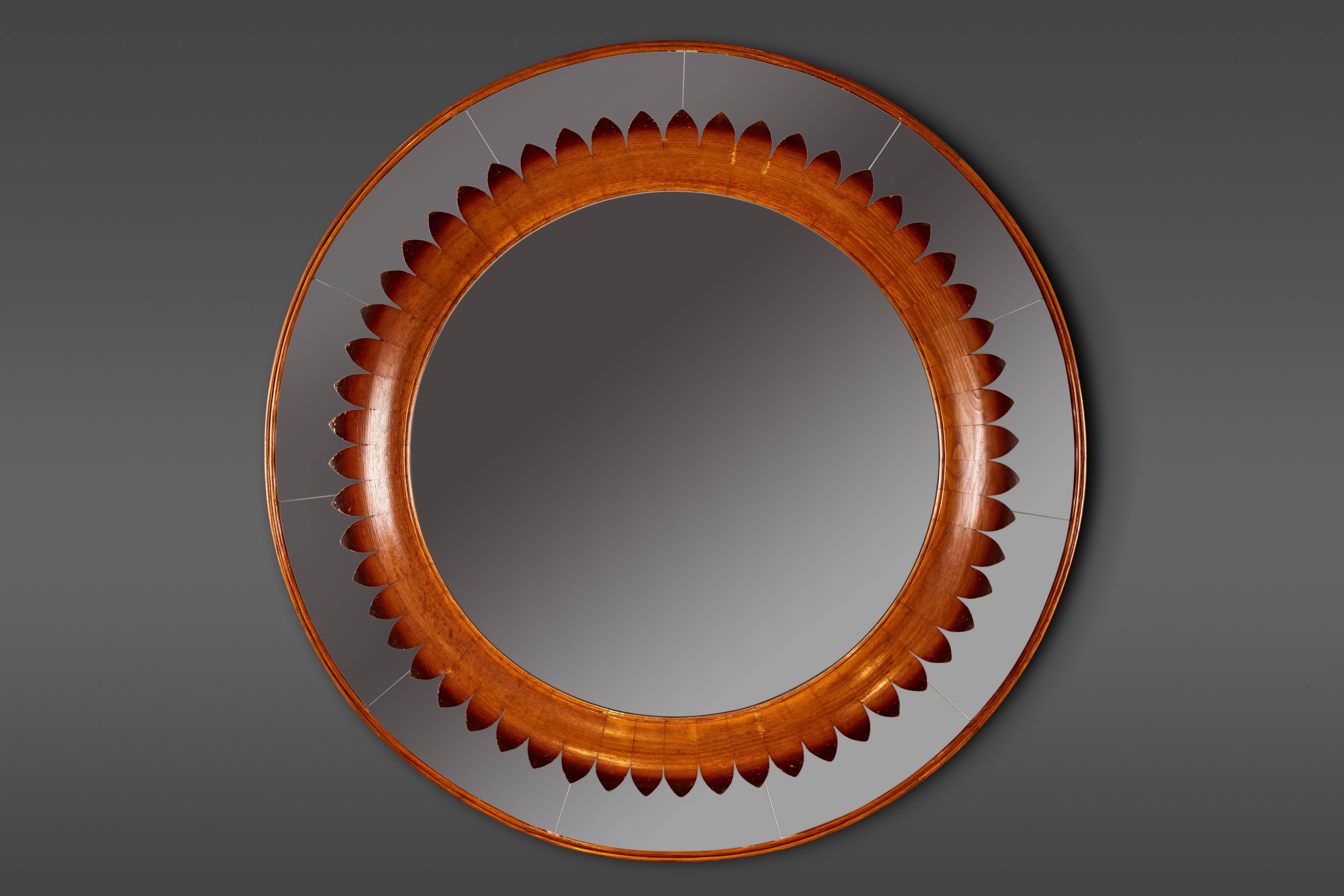 An exquisitely carved round oak mirror, double framed with a surround of segmented mirrors and wood banding.