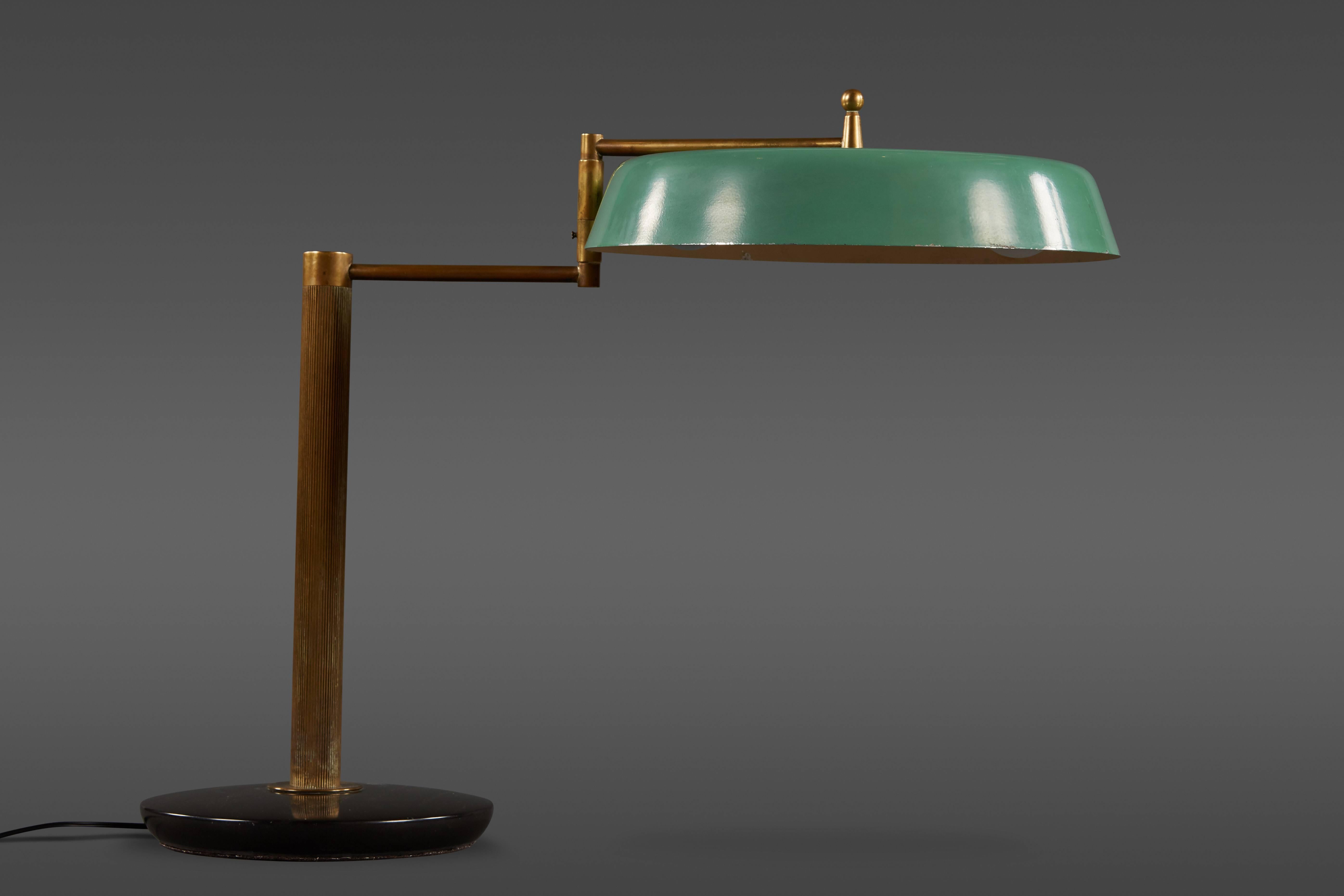 A handsome articulating Italian table lamp with green enameled shade, brass arm and brown enameled metal base.