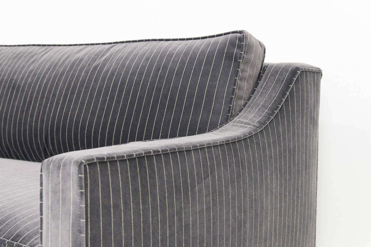 The Audrey sofa upholstered in a refined pinstriped charcoal with chrome L-legs.

Measures: 9' long/38