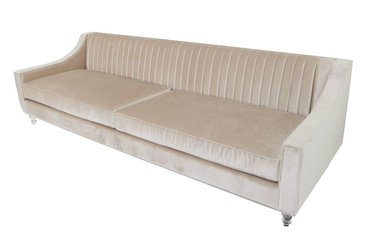 Modshop's Audrey sofa is made with cashmere velvet sofa, featuring a gentle sloping arm detail, long arm tufting and Lucite turned legs.
