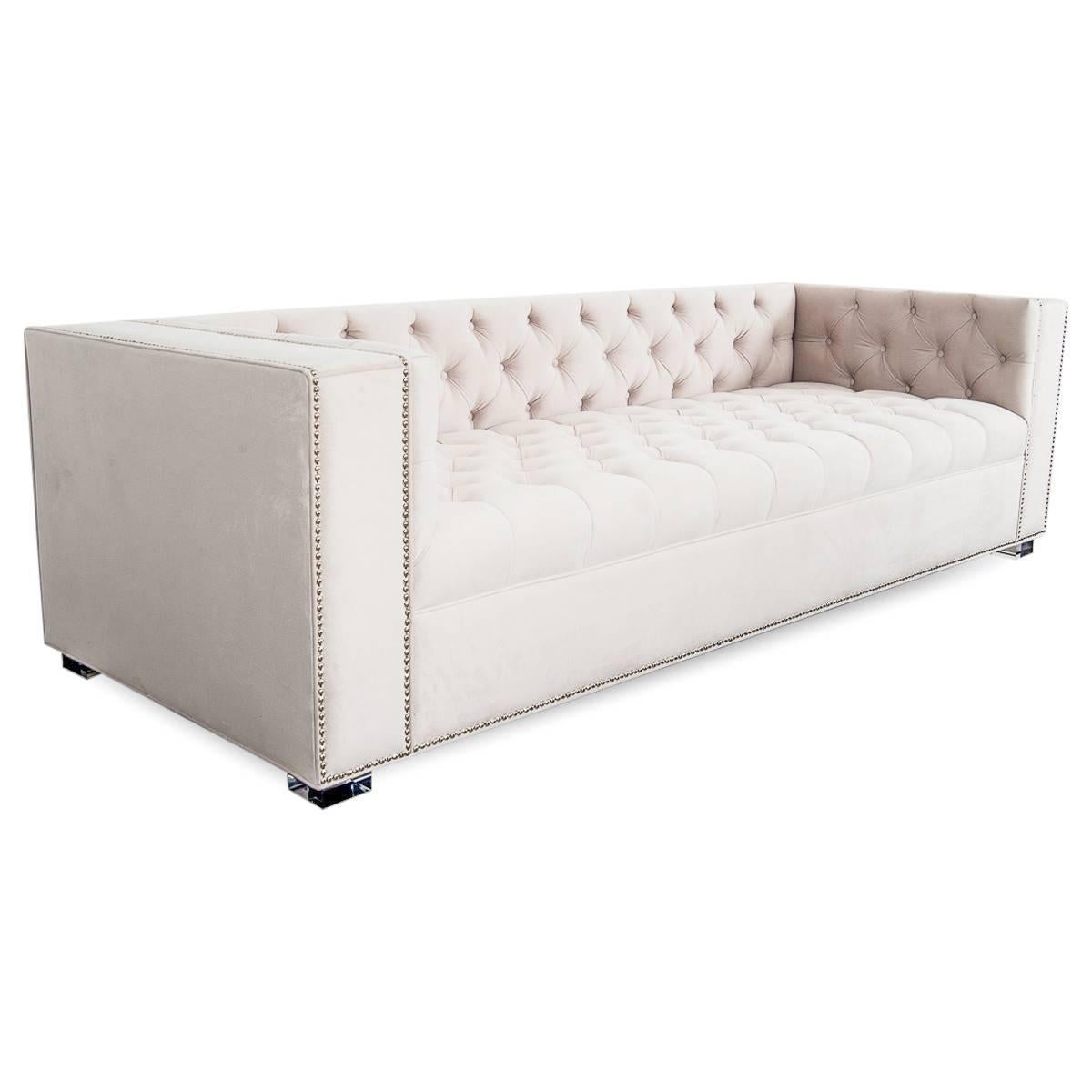 Beautifully simple lines and tufted detail combine to create this elegant sofa. Finished here in a light belvedere beach velvet, chrome nailheads and 2