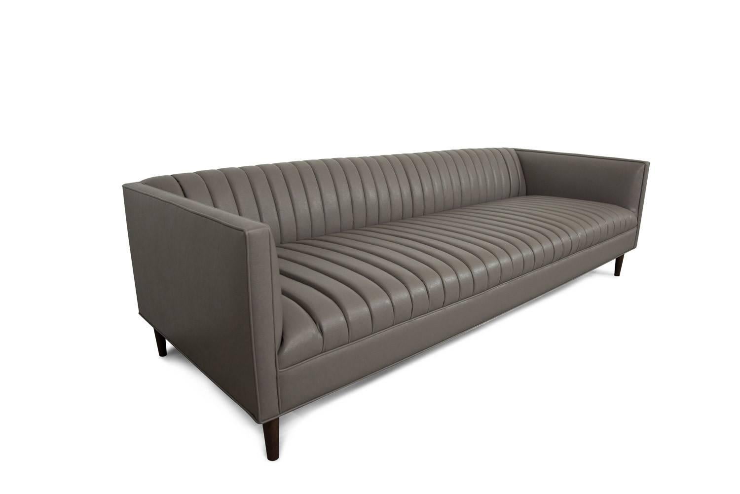 This sleek charcoal faux leather creates a contemporary long arm tufted sofa. Featuring Klein midnight faux leather and 7
