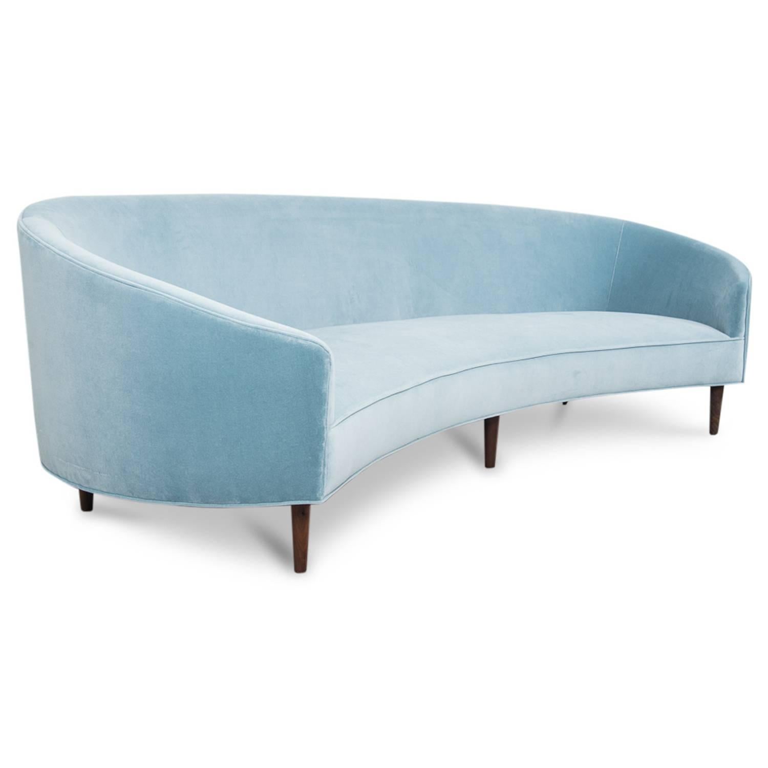 With Classic clean lines and sharp curves comes Modshop's Art Deco sofa. Uniquely shaped, similar to a crescent, curved in arms and six walnut cone legs put together in elegance. Shown in Capri blue velvet.

Measures: 105