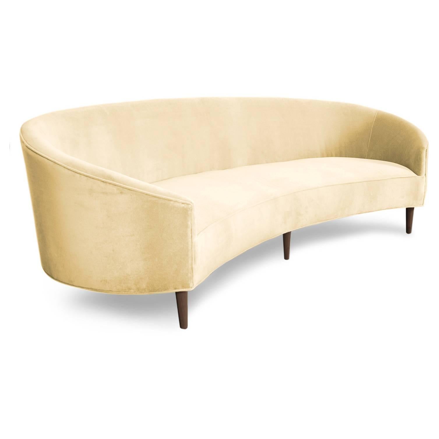 With Classic clean lines and sharp curves comes Modshop's Art Deco sofa. Uniquely shaped, similar to a crescent, curved in arms and six walnut cone legs put together in elegance. Shown in Hollandaise velvet.

Measuares: 105