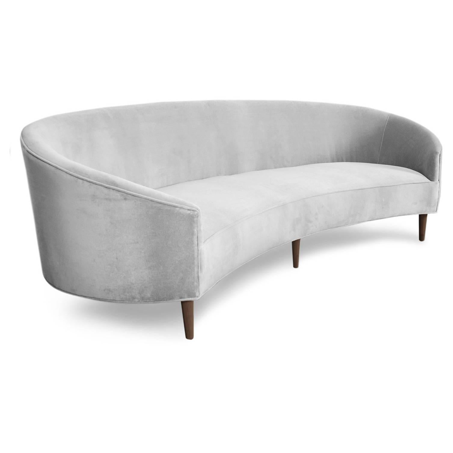With Classic clean lines and sharp curves comes this Art Deco sofa. Uniquely shaped, similar to a crescent, curved in arms and six walnut cone legs put together in elegance. Shown in Sharkskin velvet.

Measures: 105" W x 40" D x 31"