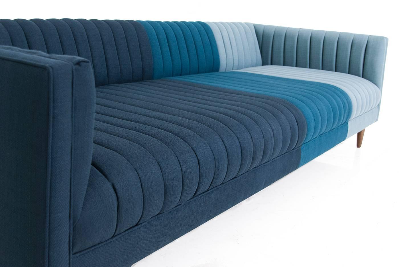 The Manhattan is Modshop's Mid-Century inspired sofa, long arm tufted Featuring Klein Midnight, Azure and Sea linens and 7