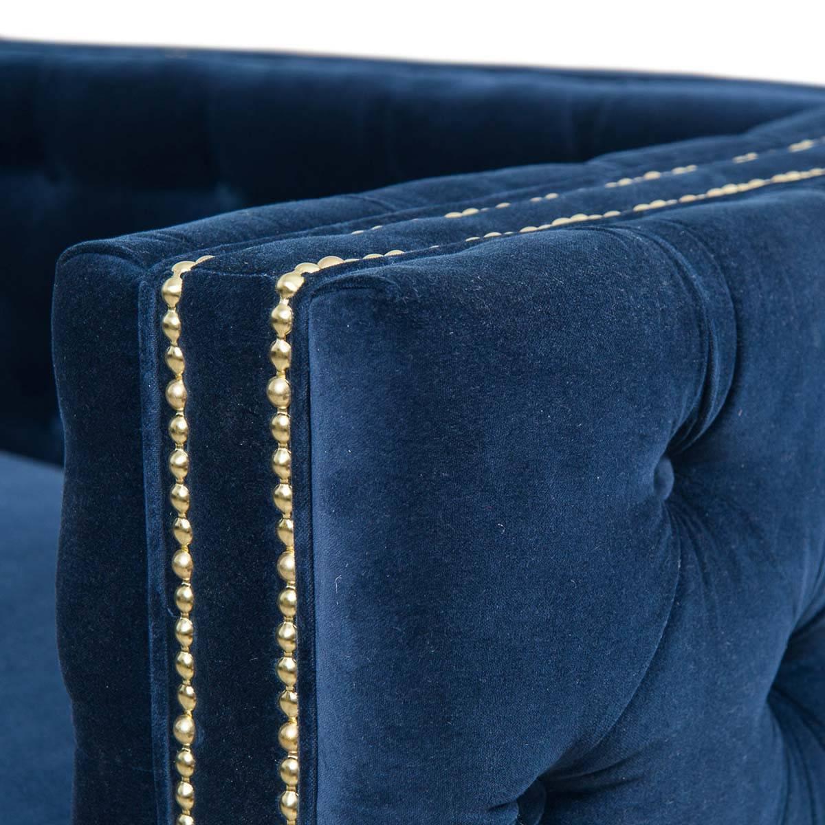 The inside out sectional features button tufting on the interior and outer sides with a flat back. With regal navy velvet, brass nailhead detailing and 7