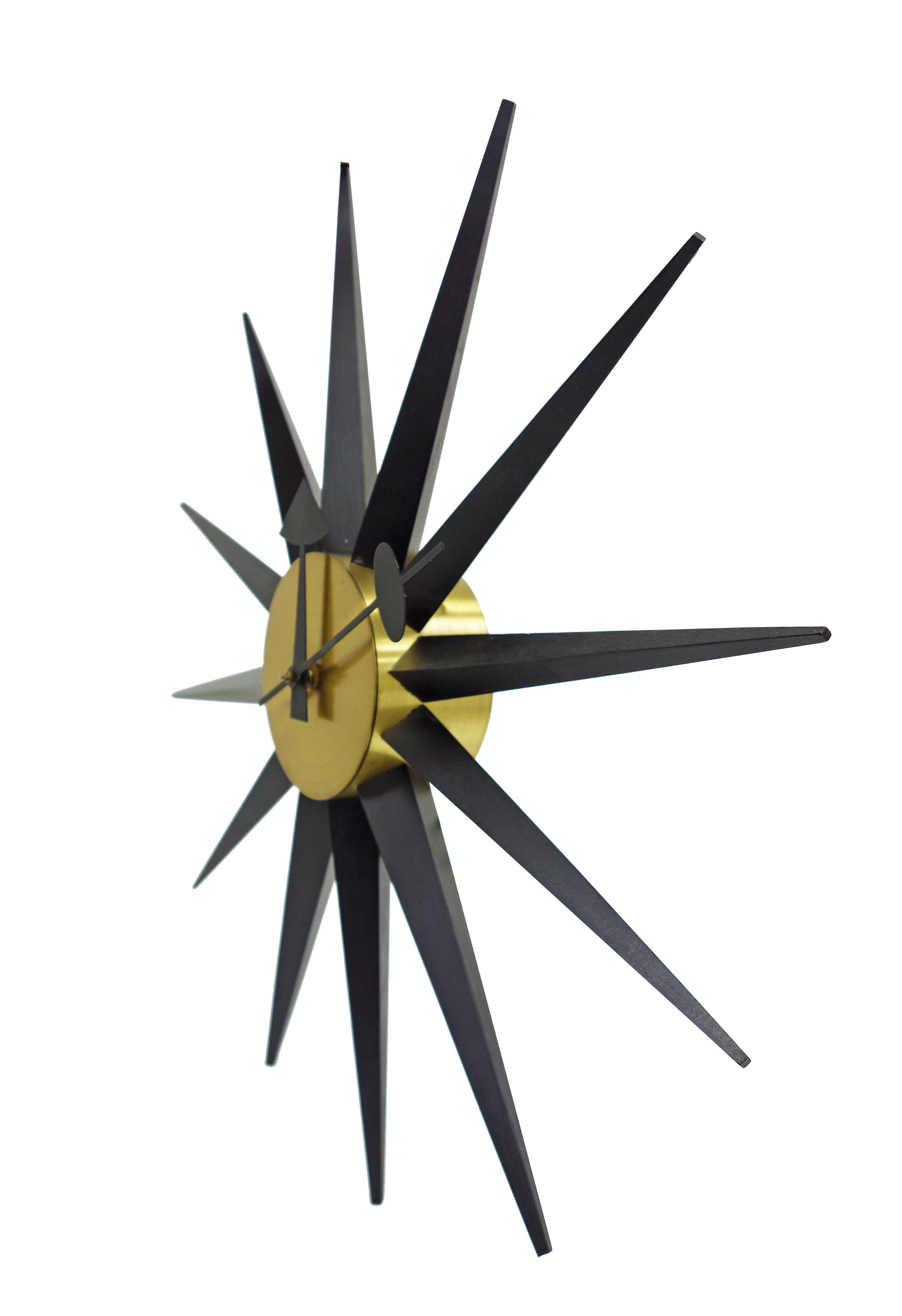 Striking George Nelson spike clock by Howard Miller. Model 2202 in painted wood and brass. Unusual black on black finish. Very good original condition.