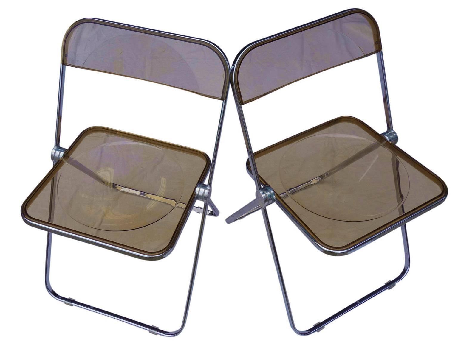 Stunning set of four Plia Lucite chairs. Impossible to find wall-mounted hanger included.