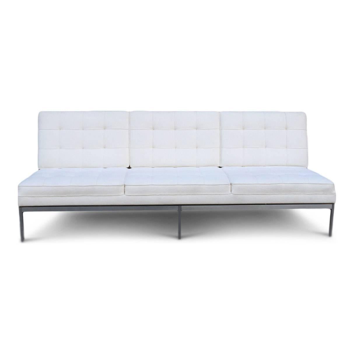 Florence Knoll for Knoll sofa, previously reupholstered in white wool Knoll fabric on a brushed steel base. It is an icon of Florence Knoll's clean Mid-Century Modern design.

This sofa with the angled bars at the back of the sofa was only