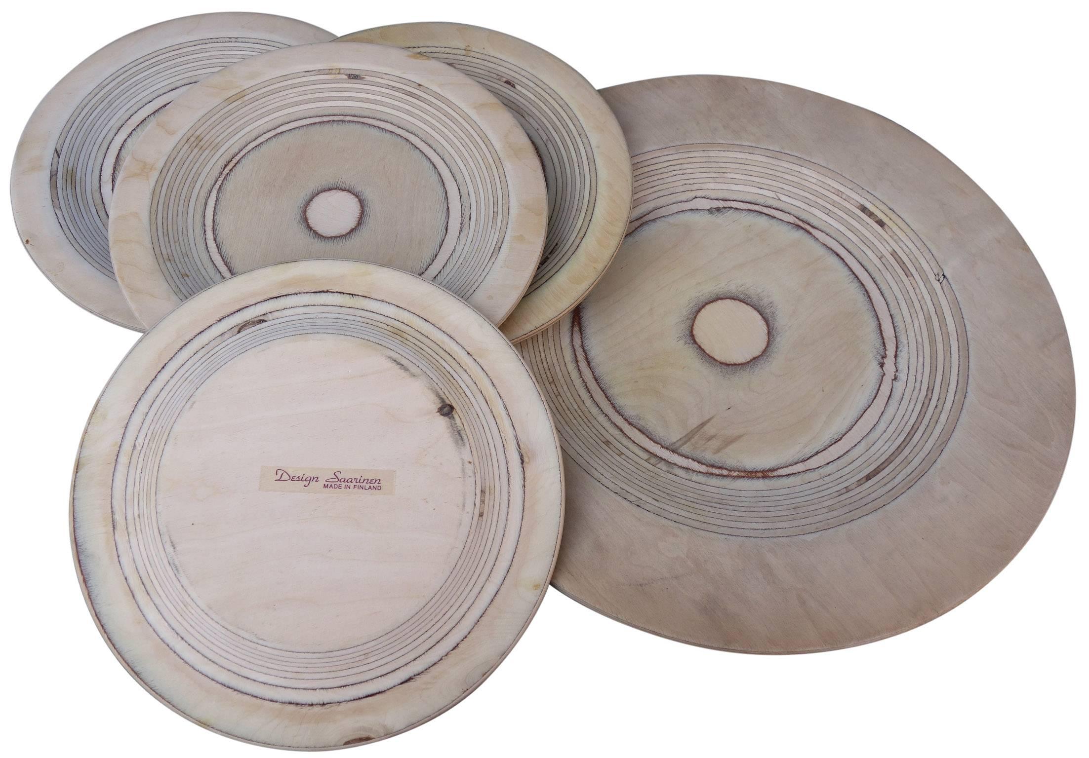 Nice grouping of five Saarinen plates. Turned birch plywood. 
Made in Finland by Keuruu.

Smaller plates 11.75