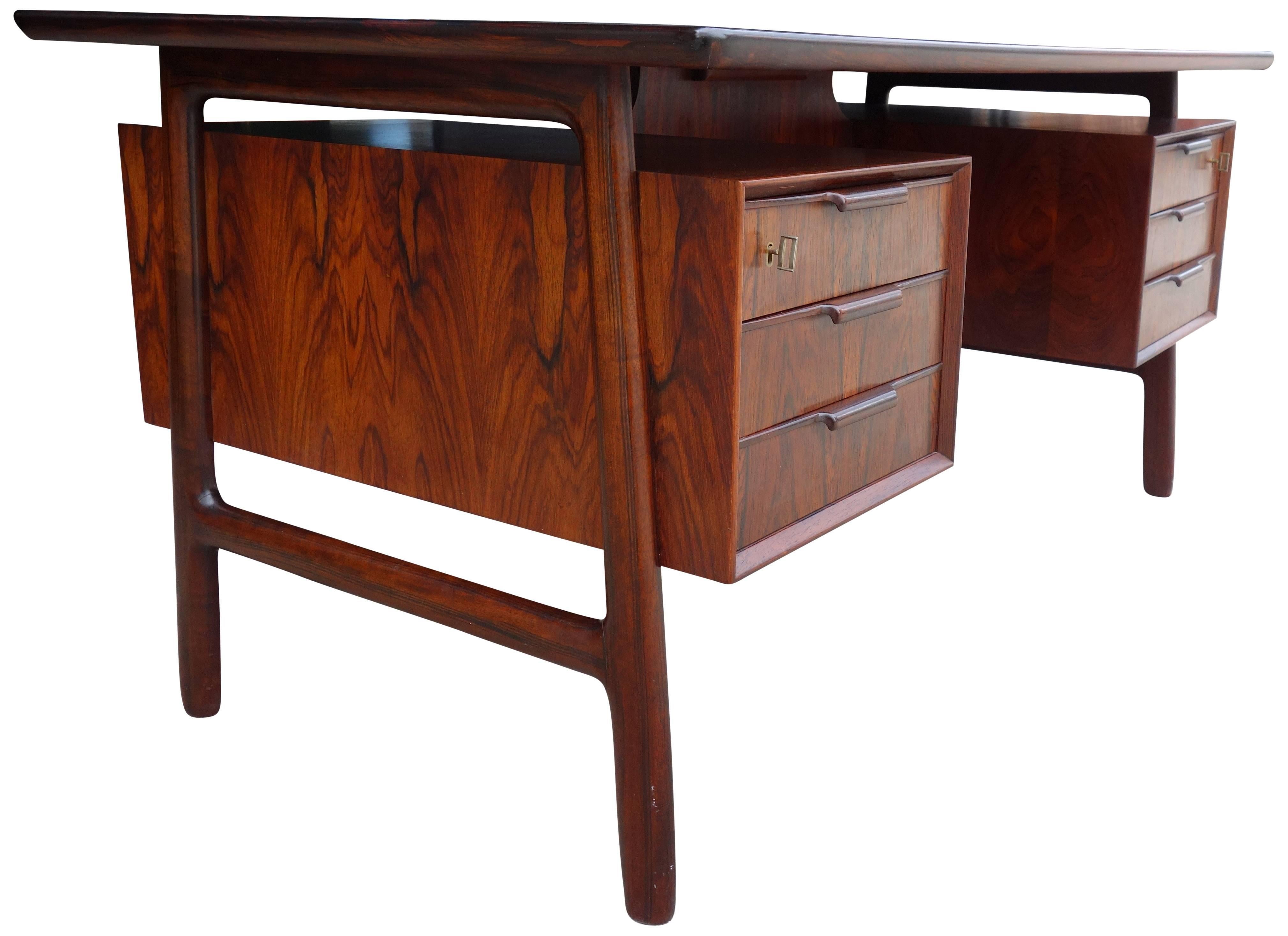 Mid-Century rosewood desk by Gunni Omann for Omann Jun.
Beautiful highly figured rosewood executive desk model 75. Front has two locking drawers and the back has a fold down cabinet with two open cabinets to store books.