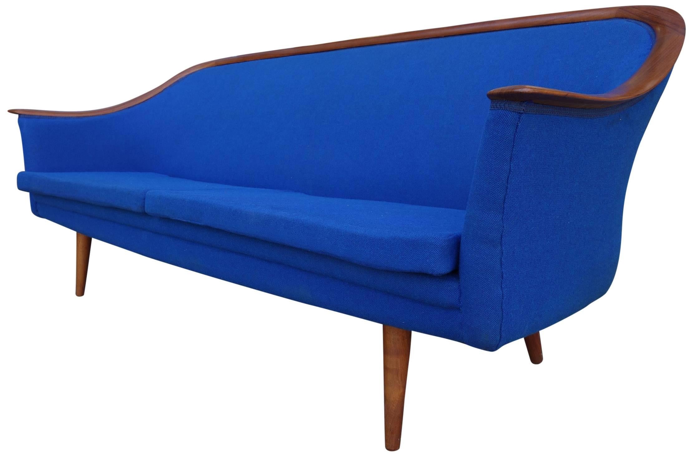 Mid-Century Scandinavian Modern sofa. Beautifully designed and masterfully constructed with teak armrest that span the length of the sofa and upholstery continues around the entire frame. Frederik Kayser was heavily influenced by Danish design