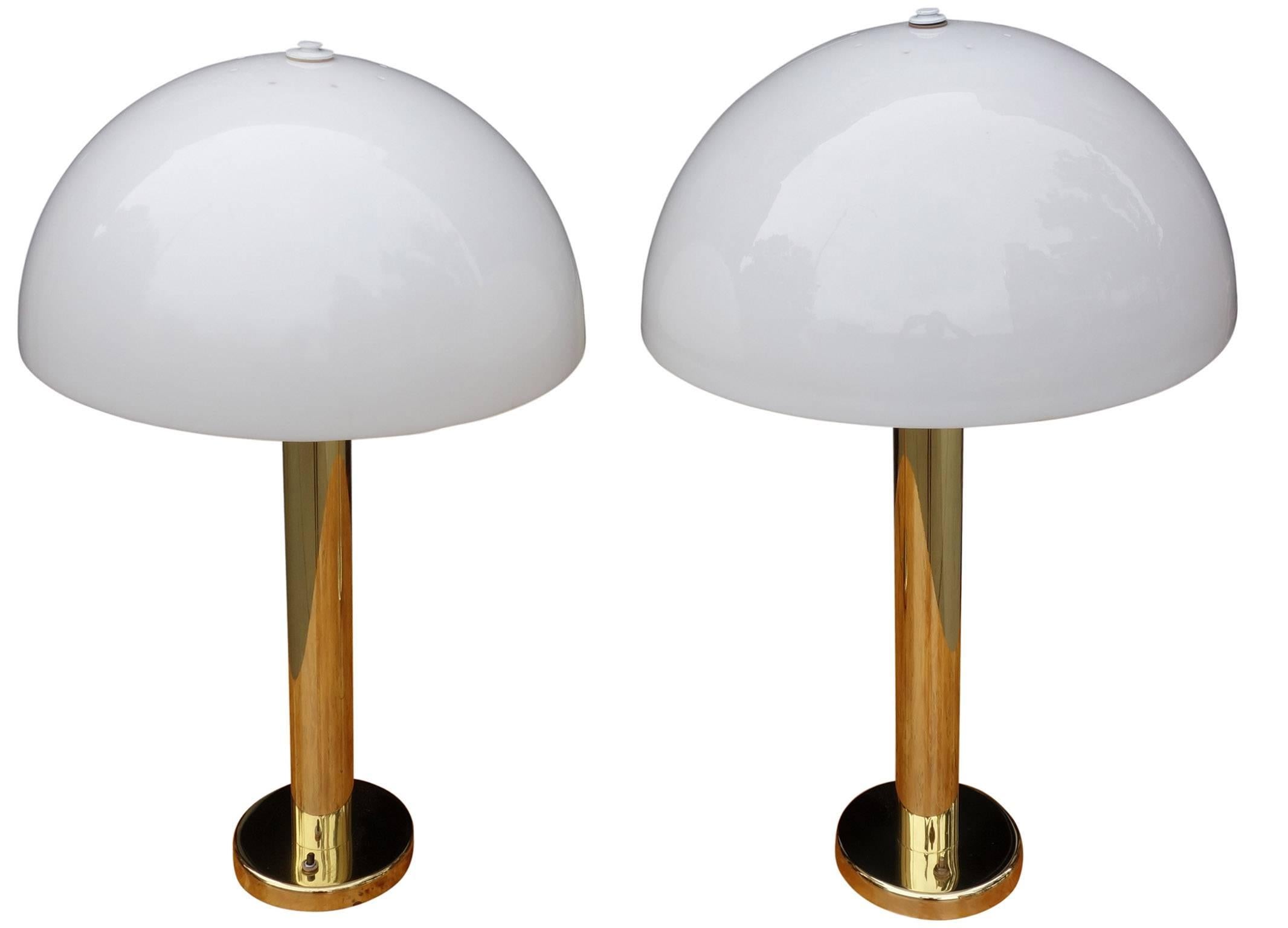 Midcentury Nessen lamps in polished brass. Original white domed acrylic shades.

Base is 6