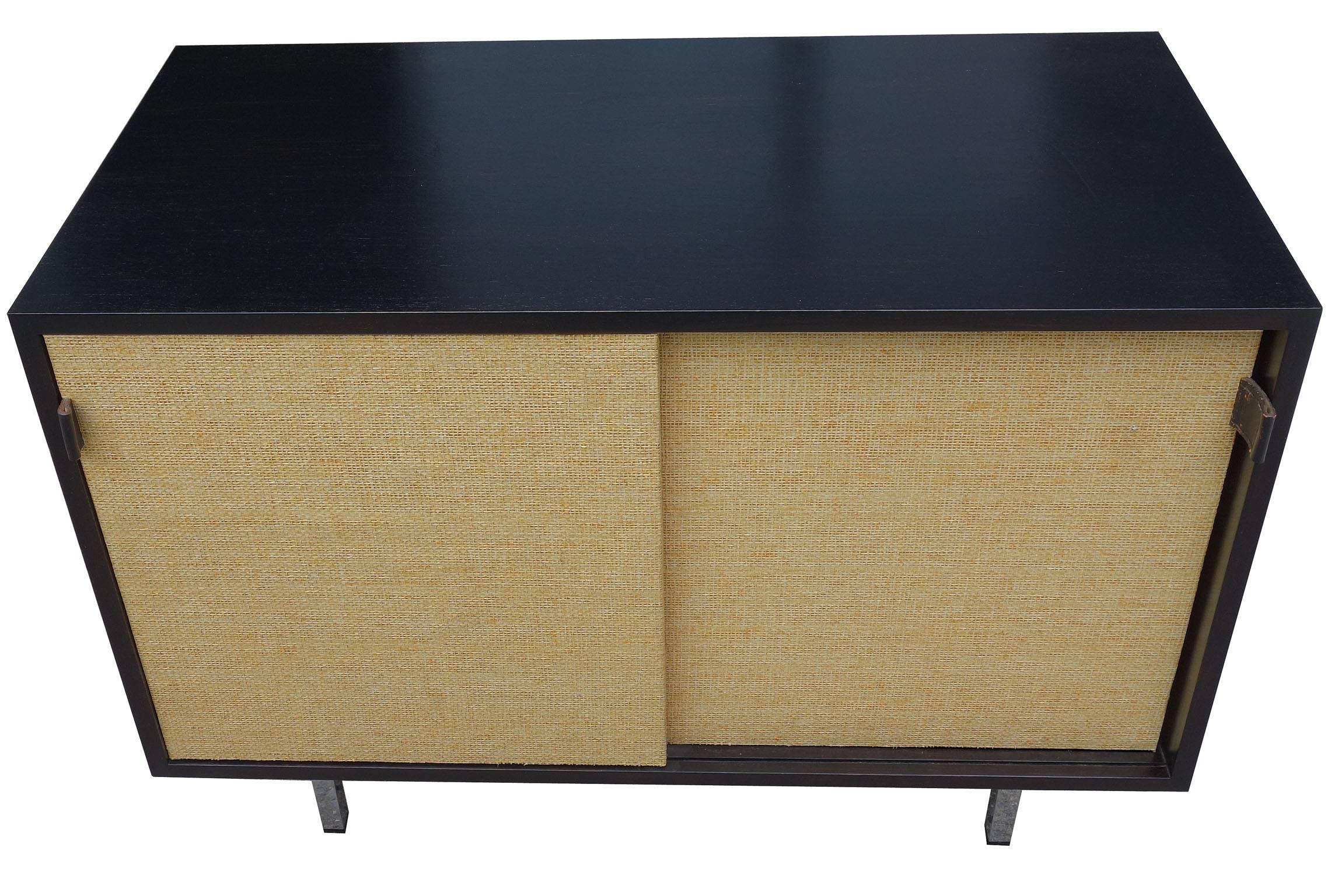 Midcentury Florence knoll cabinet. Featuring an ebonized wood cabinet on chromed steel legs. Woven doors and leather pulls are in great condition. This cabinet or credenza is an ideal size perfect for any room that needs more storage.
