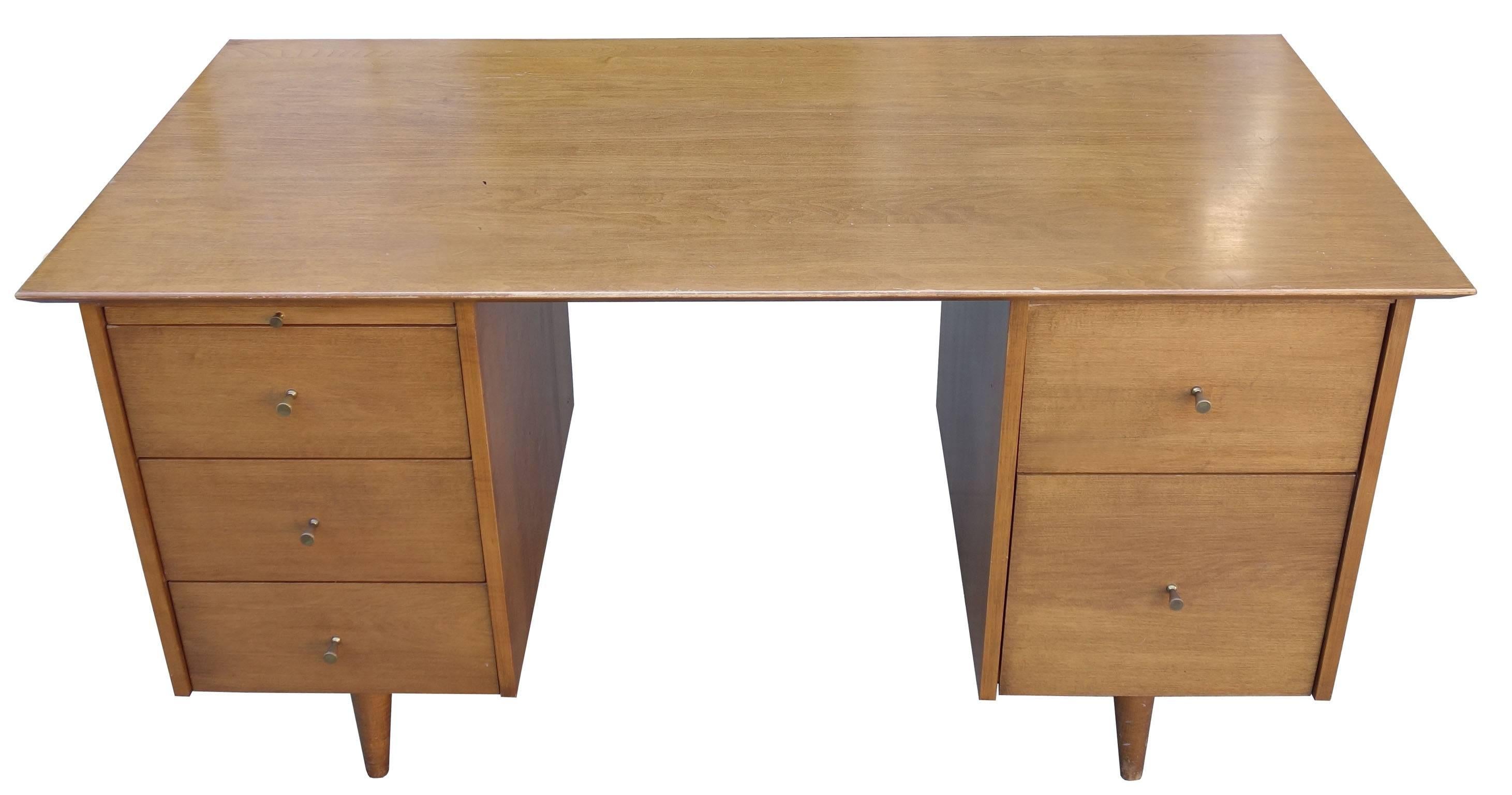 Midcentury Paul McCobb pedestal desk with five drawers and a pull-out writing tray. Part of the Planner Group manufactured by Winchendon Furniture Company in the 1950s. Features the Classic McCobb hourglass pulls. Made of solid birch and original