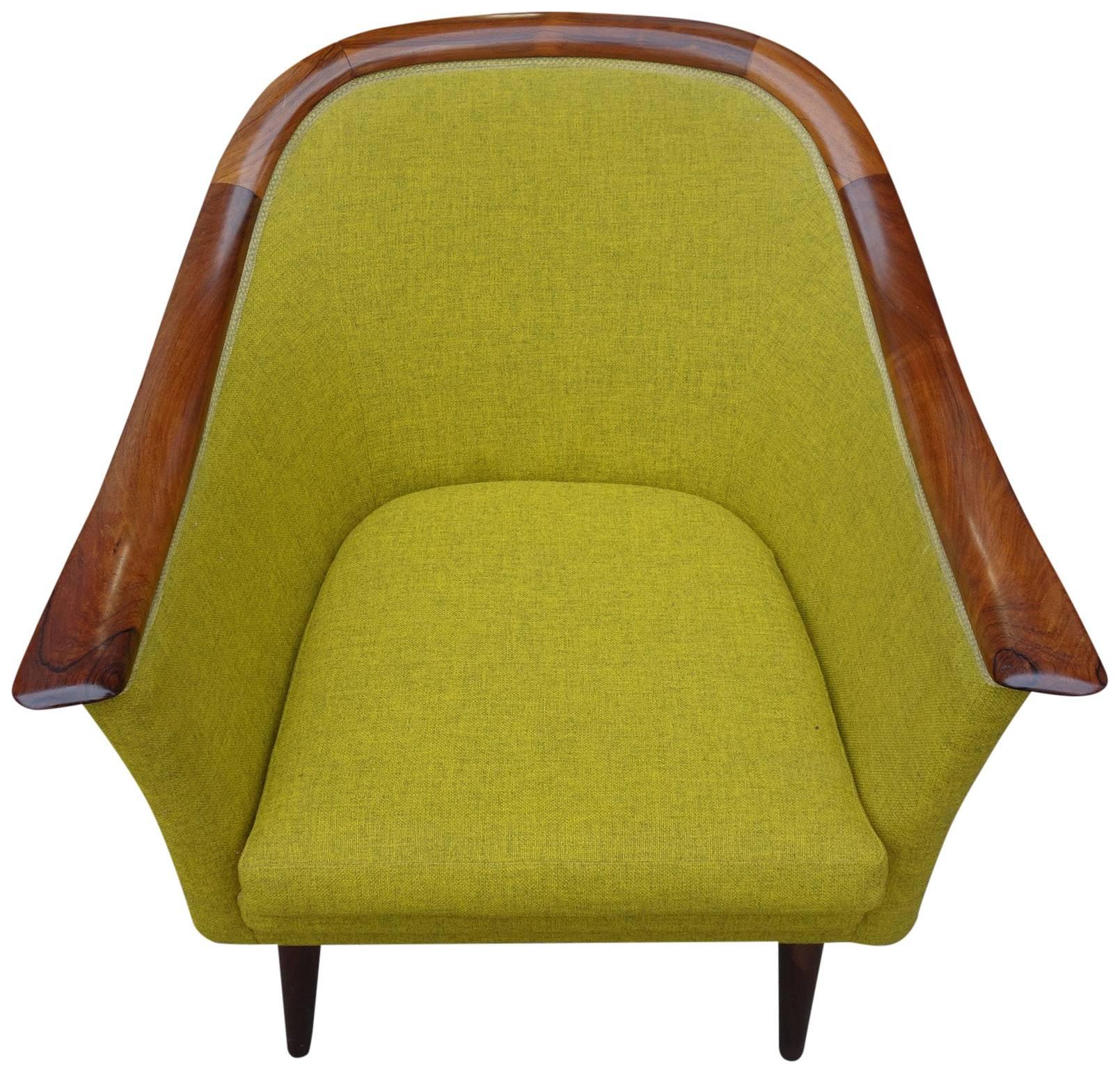 Mid-Century Scandinavian Modern club chair. Beautifully designed and masterfully constructed with rosewood armrest that spans the length of the chair. The upholstery continues around the entire frame. Highest quality that challenges greater known