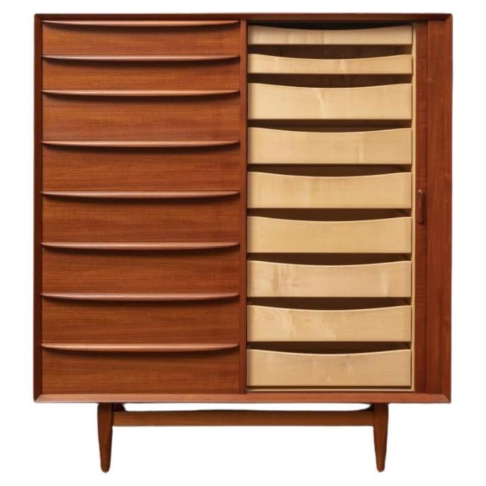 Mid century Danish Modern tall teak dresser has 8-drawers on left. Clean inside and out - labeled Falster - Made in Denmark. Good vintage condition. Has right cabinet door with 9 drawers behind the Tambour door. Very clean all around inside and out.