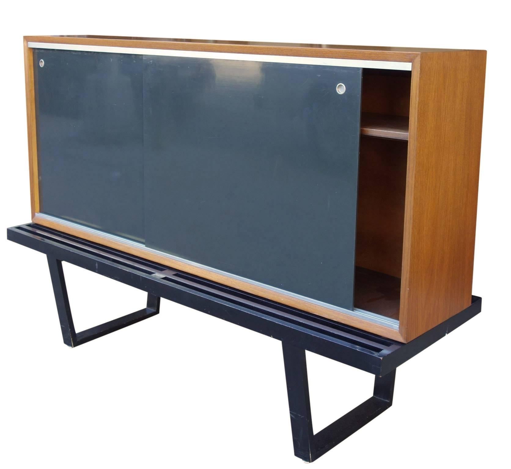 Wonderful example of the Herman Miller modular system designed by George Nelson. This piece features the rare sliding door cabinet with adjustable shelves. In original unrestored condition, 1952.
Measures: Cabinet depth is 12'' and the height is