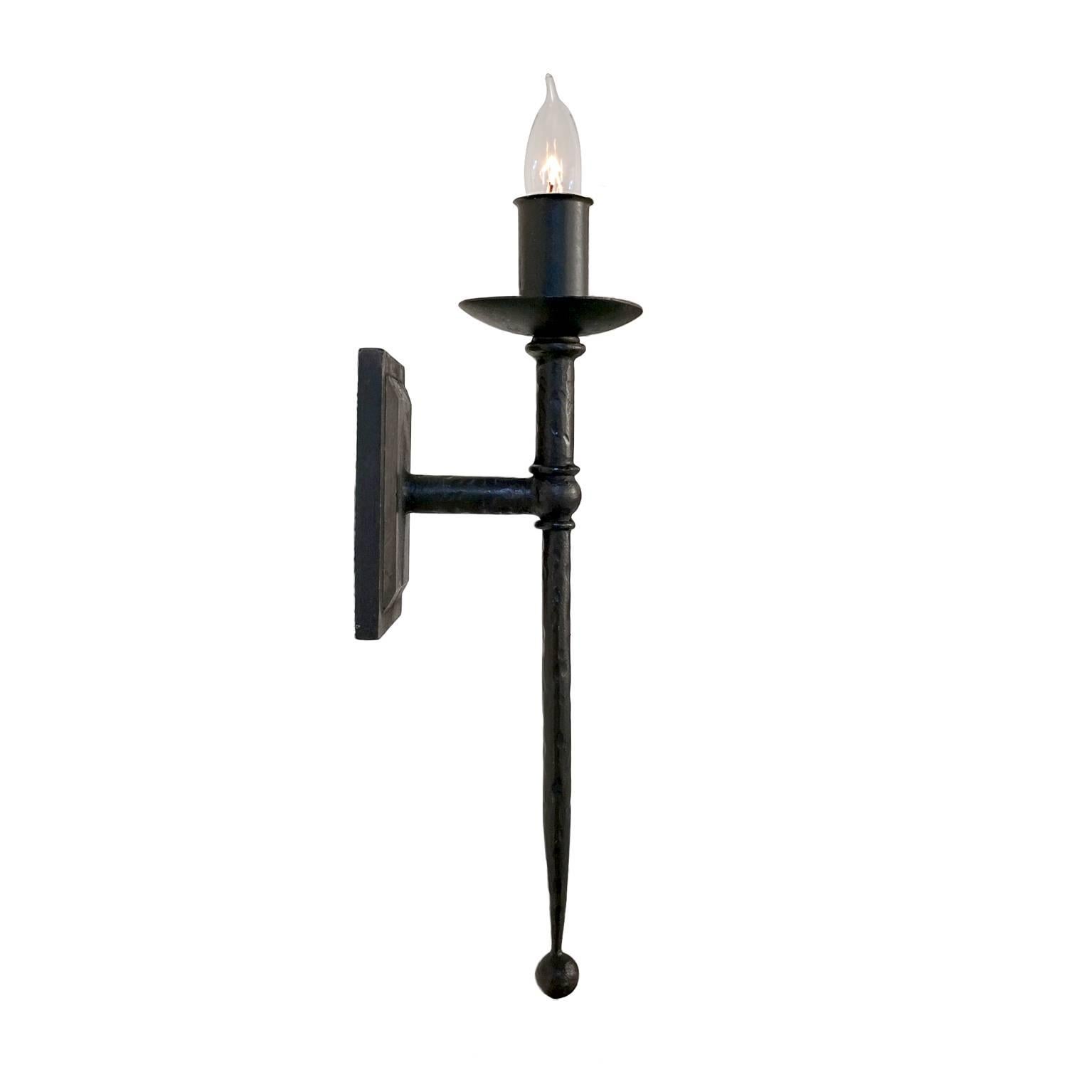 Elegant wall sconce with gentle tapering, clean lines and classic torcheire details.  Hammered texturing and a rich waxed finish gives this wrought iron fixture a softer look.  At home in a classic Mediterranean or Spanish Colonial backdrop. 