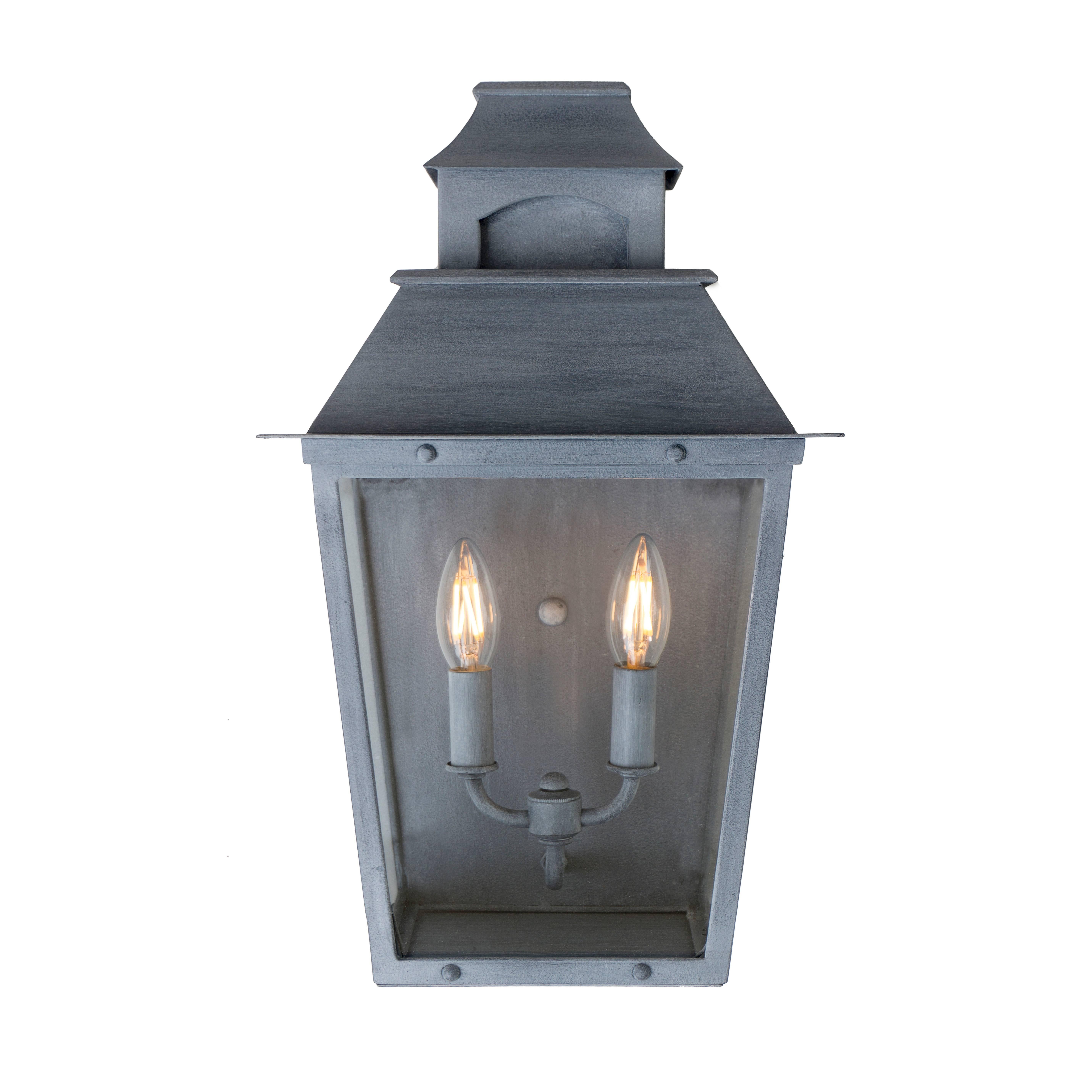 Elegantly appointed exterior wall sconce capturing the essence of a true colonial lantern.

Flush wall mount lantern with clear glass and a premium zinc finish. 
Two candelabra max wattage 80.
Center mounting hole.

[Finish samples are available.