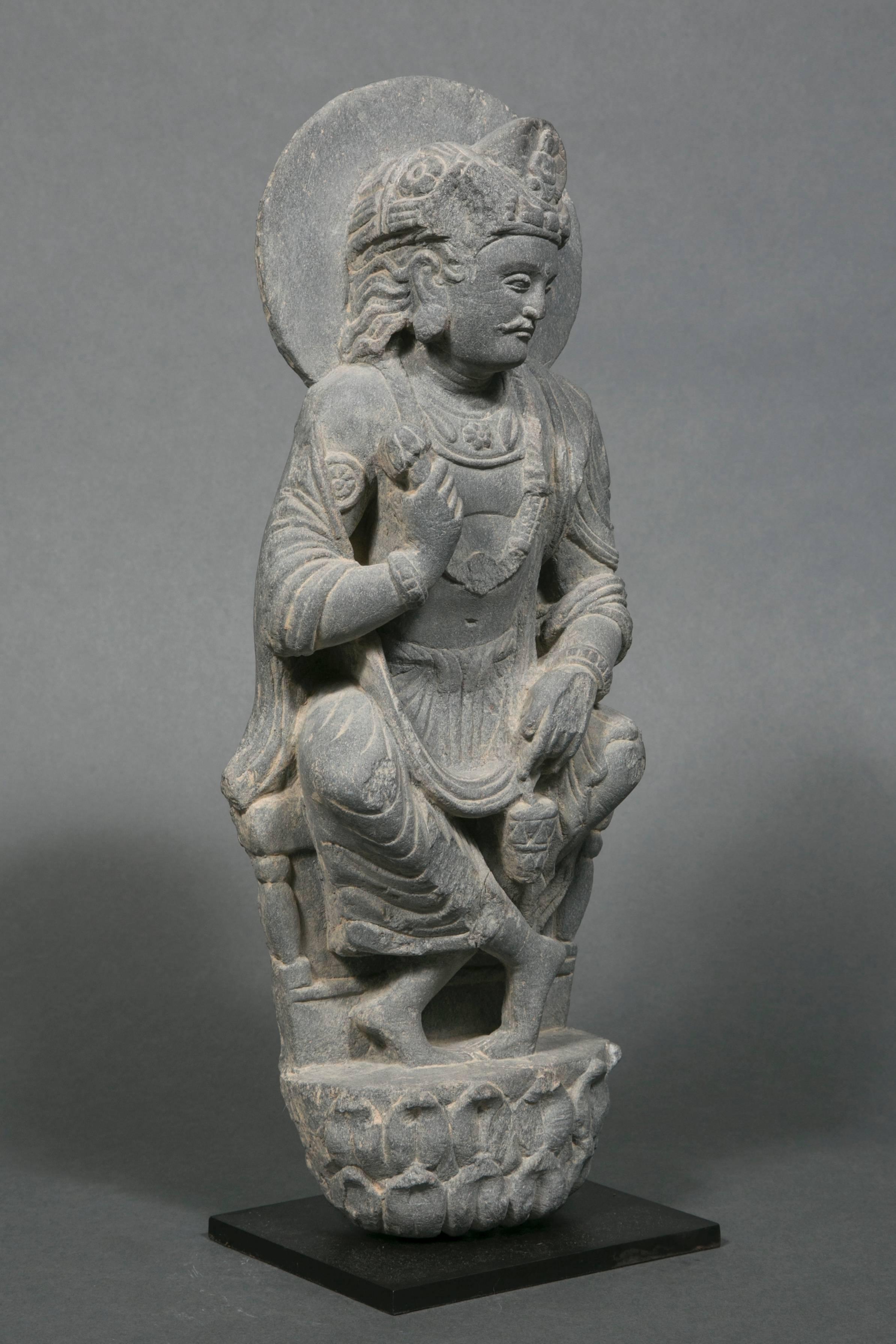 Bodhisattva Padmapani in gray schist, crowned, seated in the European fashion on a throne. He holds in his left hand and a lotus flower and in his right hand the holy water vase.
Pakistan-Afghanistan, Gandhara region, Greco-Buddhist Art (2nd-4th