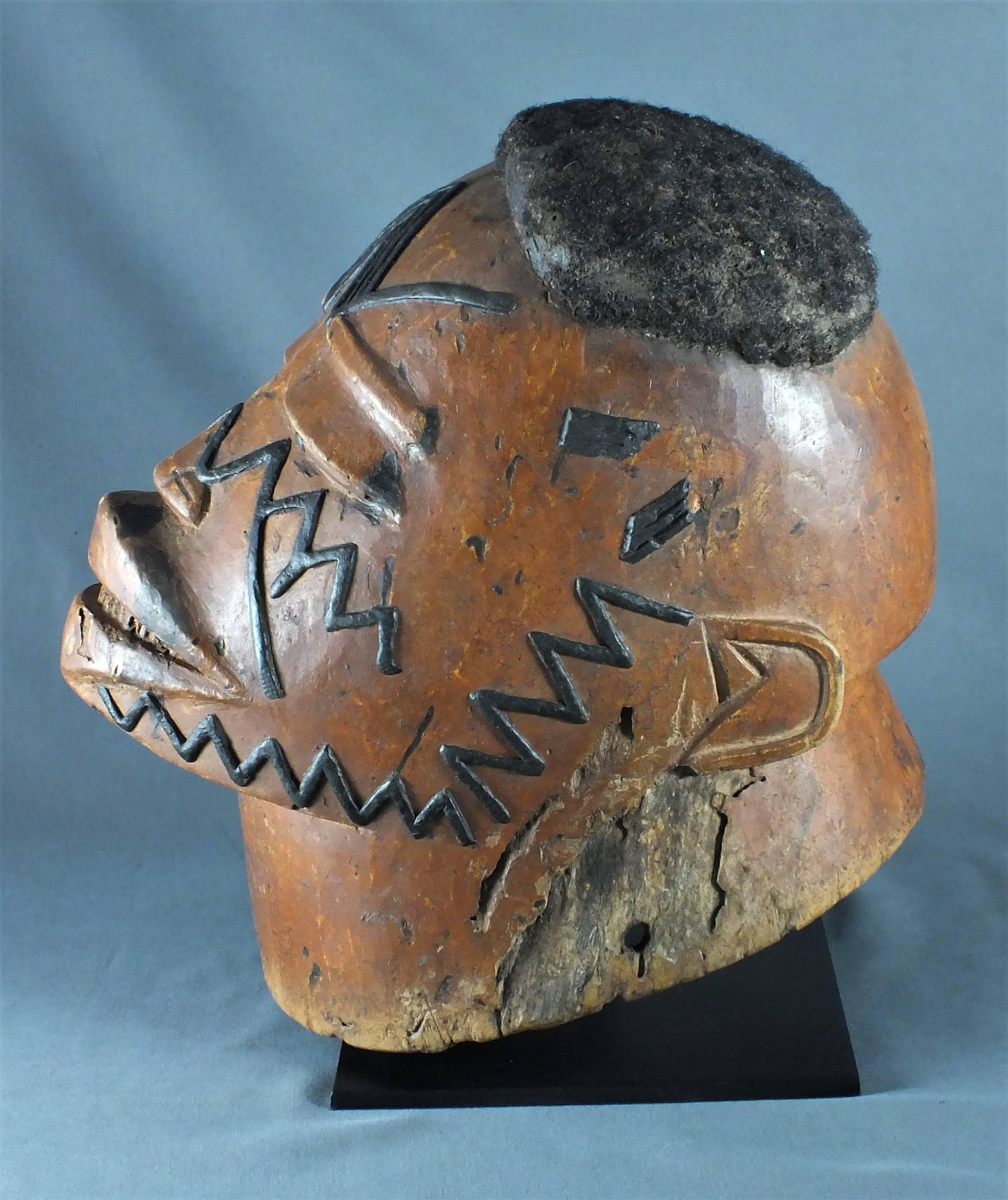 Makonde mask, Tanzania, East Africa early 20th century
Dimension: 23 x 15 x 25 cm
Dimension with stand: 28 x 15 x 26 cm

Helmet mask Makonde, Tanzania. Hard wood with very old patina of use light brown, hair, copper and wax.

This old helmet