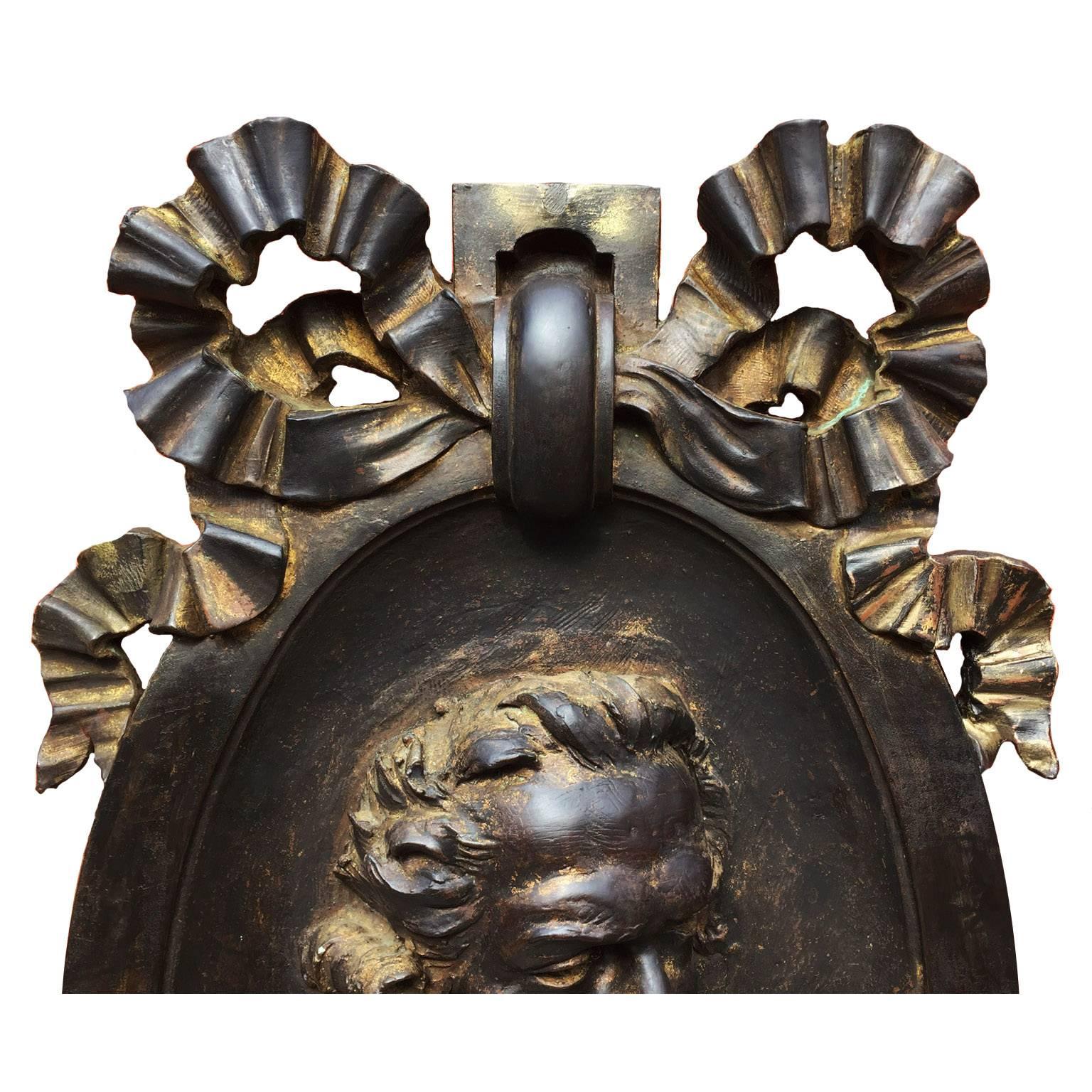 Un grand et rare médaillon en relief du 18ème-19ème siècle en cuivre superposé représentant le célèbre chimiste français ANTOINE LAVOISIER (1743-1794). L'écu de forme ovoïde est couronné d'un grand nœud papillon dans un anneau centré avec le buste